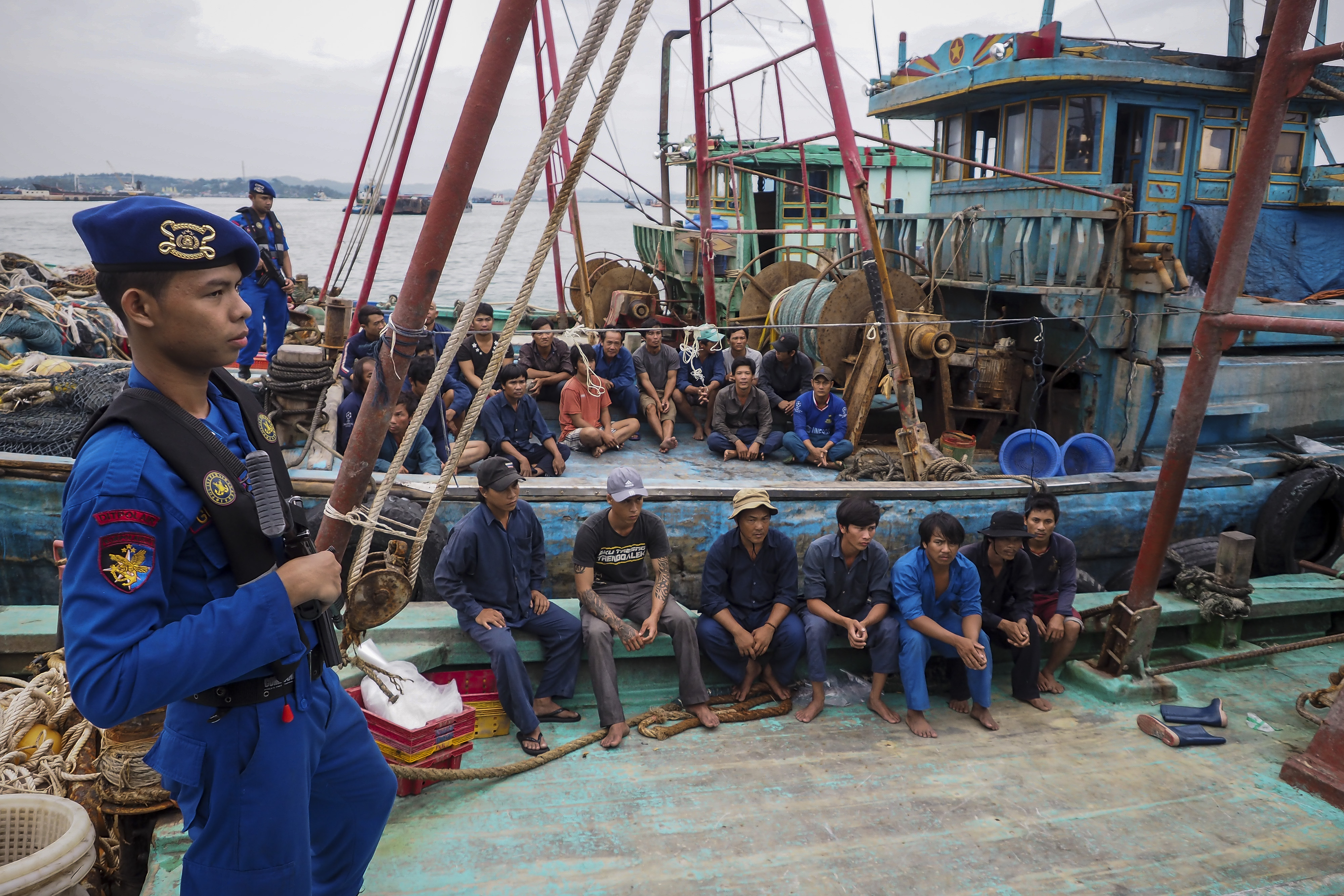 Anggota polisi Polairud Baharkam Polri menjaga kapal berbendera Vietnam dan  ABK yang tertangkap ketika melakukan illegal fishing
