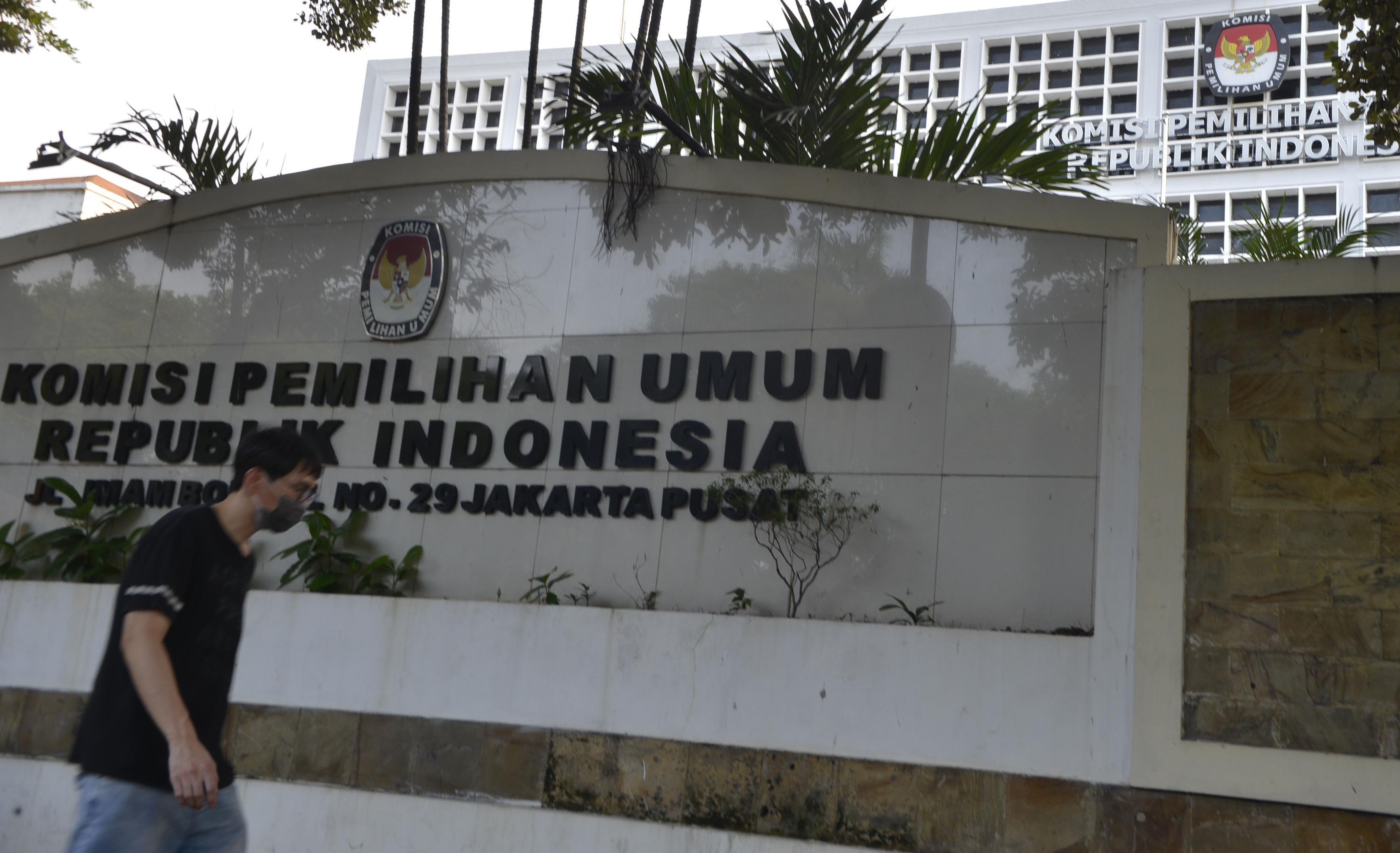 Pejalan kaki menlintasi Gedung Komisi Pemilihan Umum (KPU)-RI di Jakarta, Minggu (22/3).