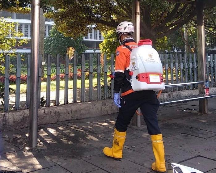 Bazis DKI melakukan penyemprotan desinfektan di Halte Busway Patung Kuda di Monas hingga Stasiun Jakarta Kota, Minggu (15/3). 