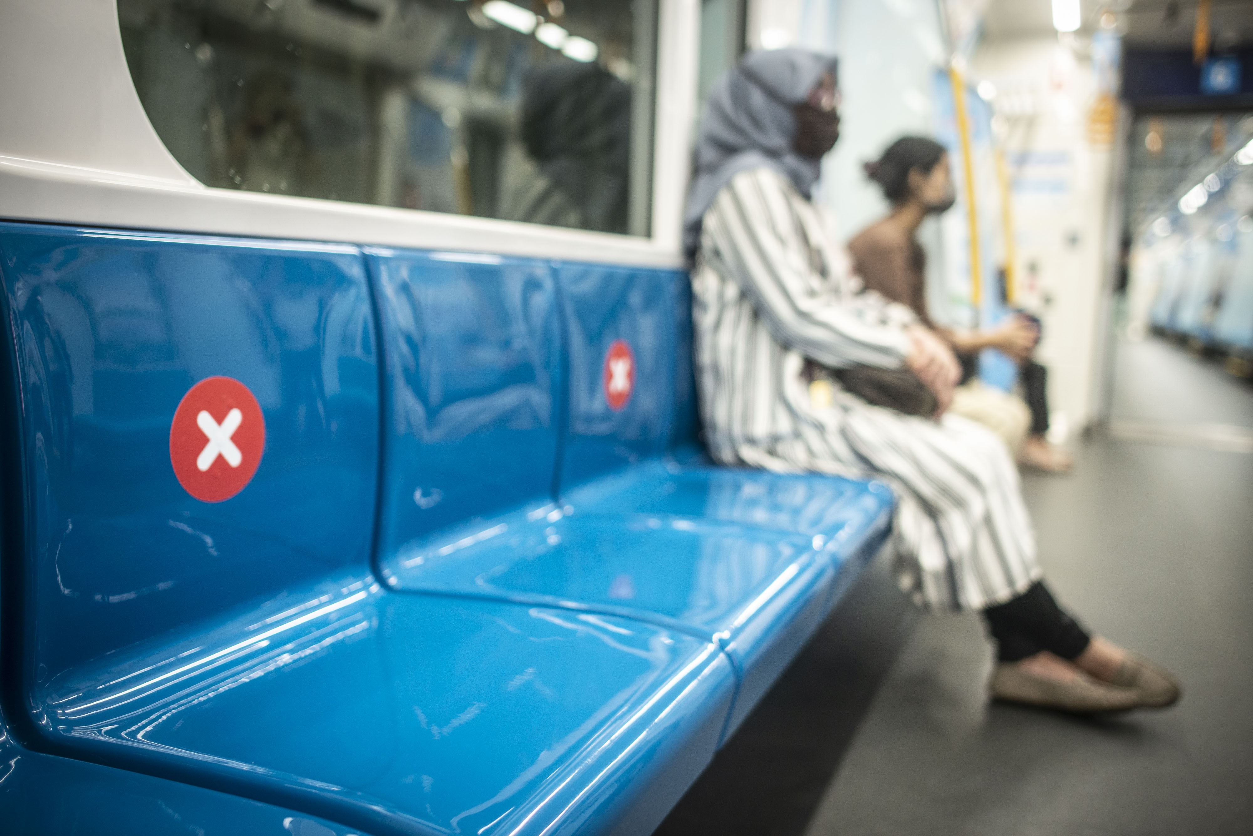 Penumpang duduk di bangku yang diberi stiker panduan jarak di rangkaian gerbong kereta MRT Jakarta, untuk mencegah penularan virus korona.