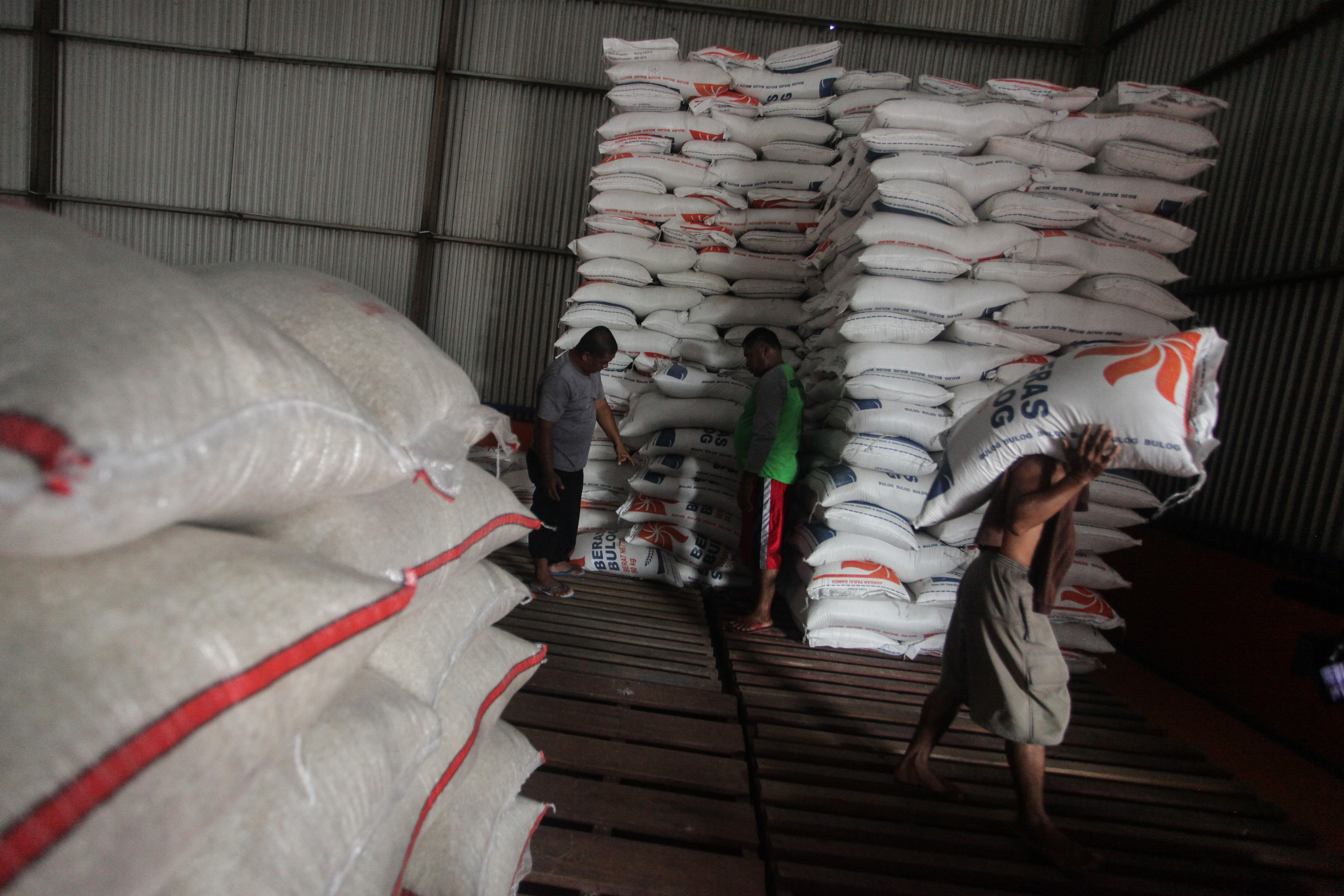Pekerja mengangkut beras di gudang Perum Bulog Regional Palangka Raya.