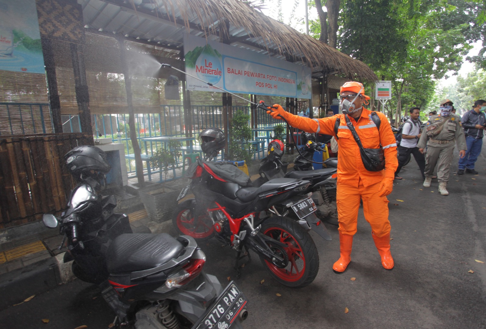Petugas menyemprotkan cairan disinfektan di Pos Wartawan Foto Bundaran HI, Jakarta
