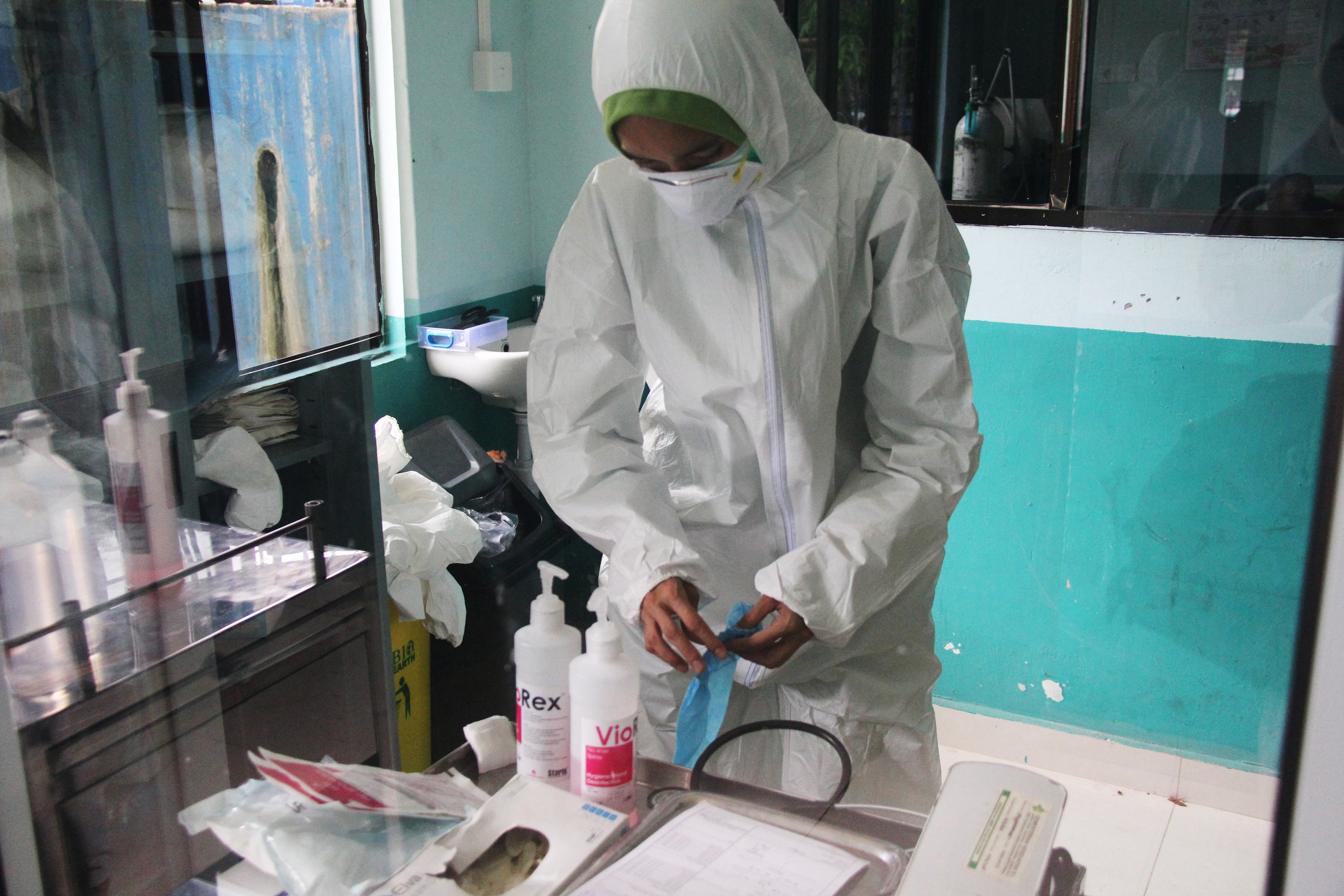 Petugas kesehatan bersiap memakai alat pelindung diri untuk merawat pasien suspect korona