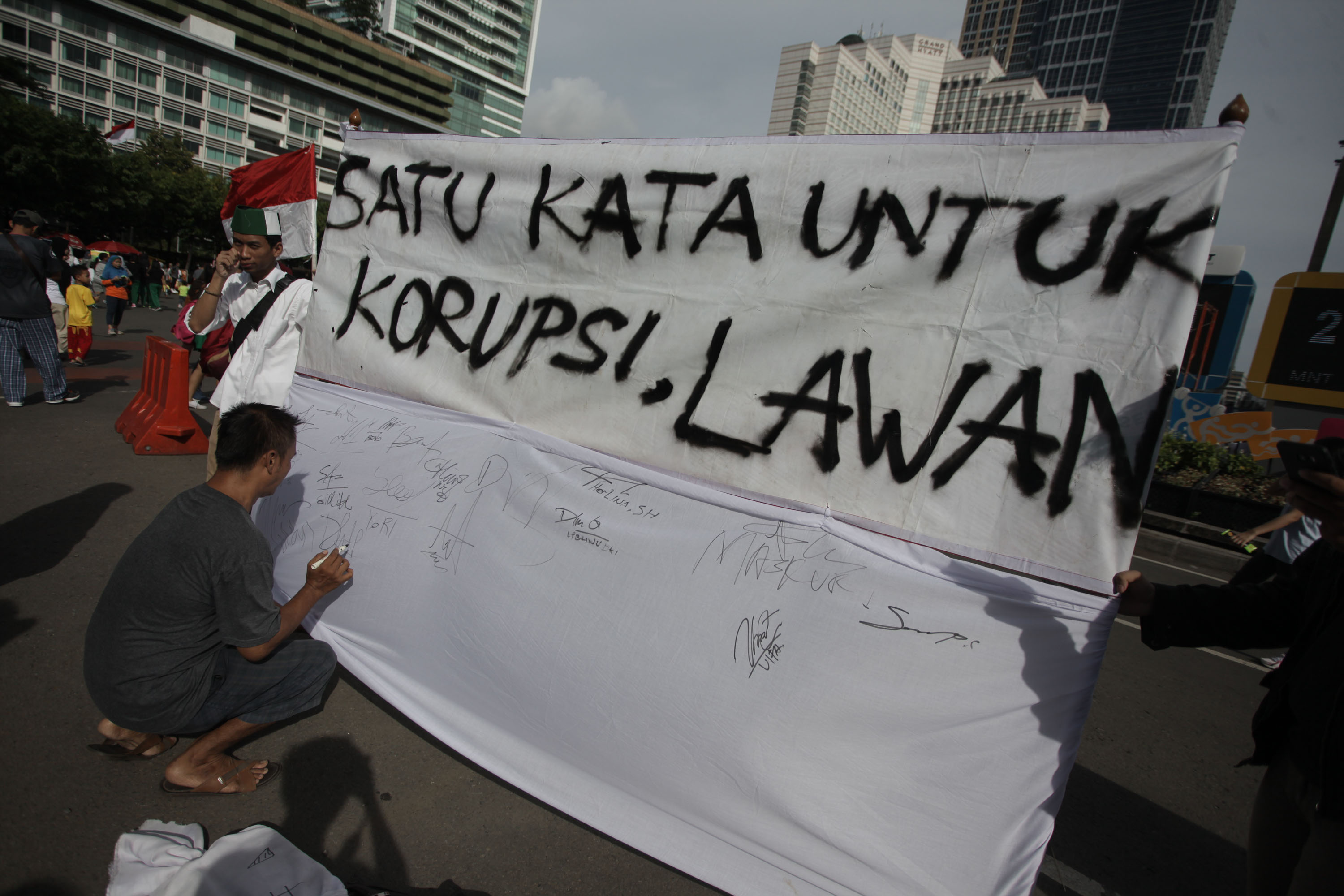Warga menandatangani spanduk dukungan antikorupsi dalam Hari Bebas Kendaraan Bermotor (CFD) di Jakarta.