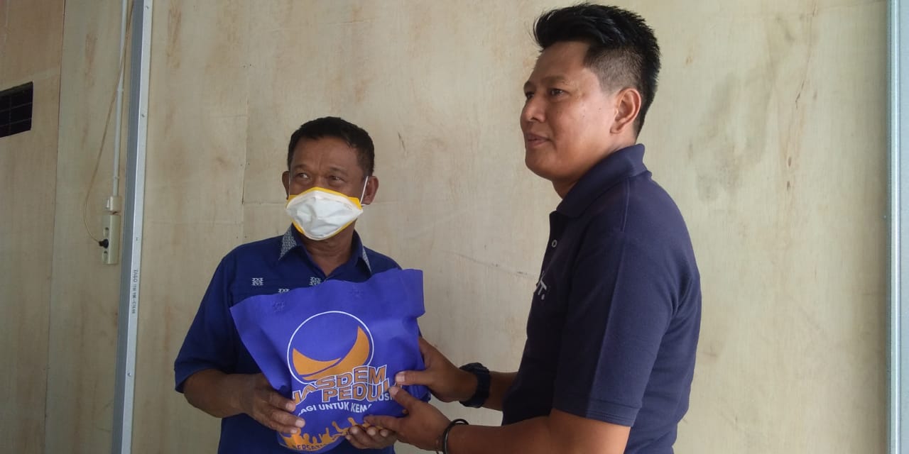 Ketua Dewan Pertimbangan DPW Nasdem Sulteng, Rusdi Mastura memberikan masker secara simbolis kepada para wartawan di Palu.