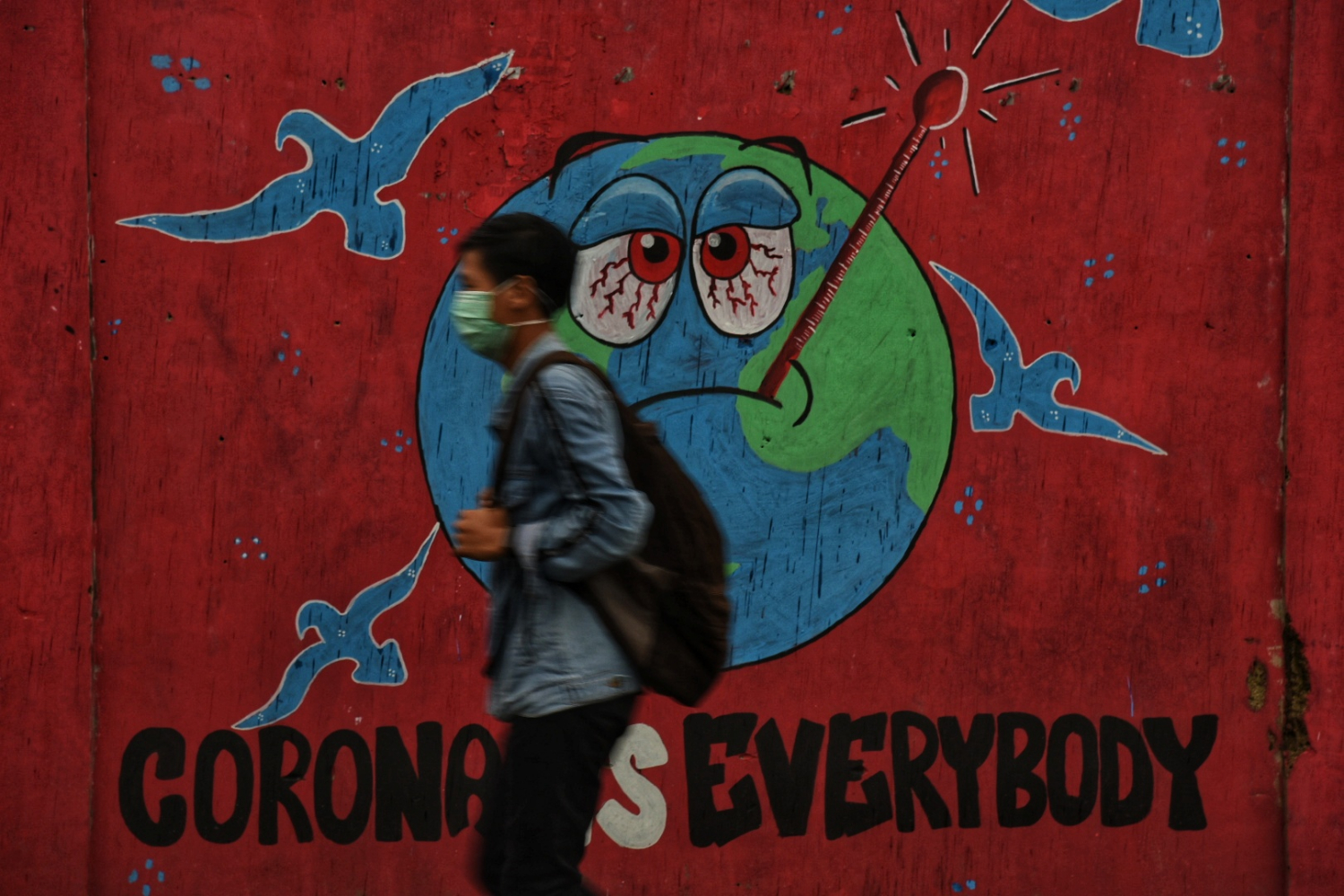  Warga melintas di depan mural terkait pandemi virus korona di  Benda, Kota Tangerang, Banten, Senin (30/3/2020). (ilustrasi)