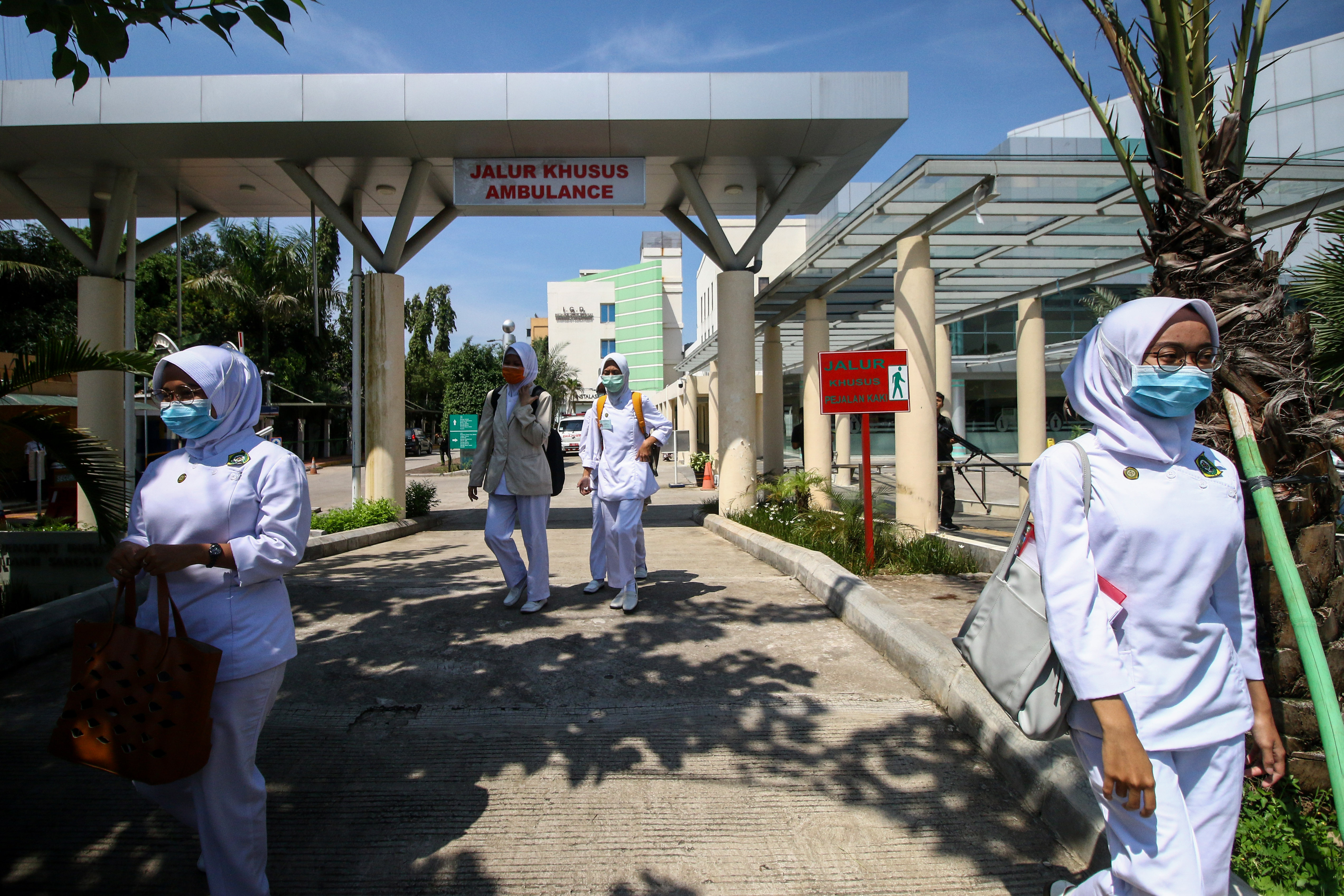 Pekerja menggunakan masker di RSPI Sulianti Saroso, menyusul perawatan dua orang positif terjangkit virus korona.