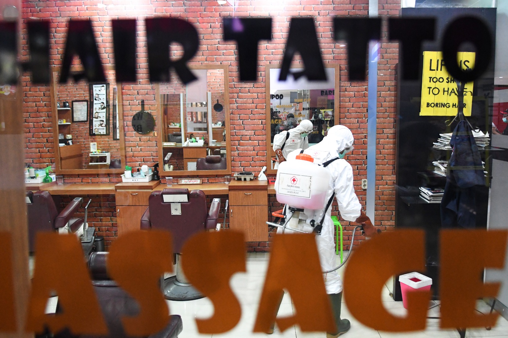 Petugas Palang Merah Indonesia (PMI) melakukan penyemprotan cairan disinfektan pada salah satu stan di pusat perbelanjaan Sarinah, Jakarta 