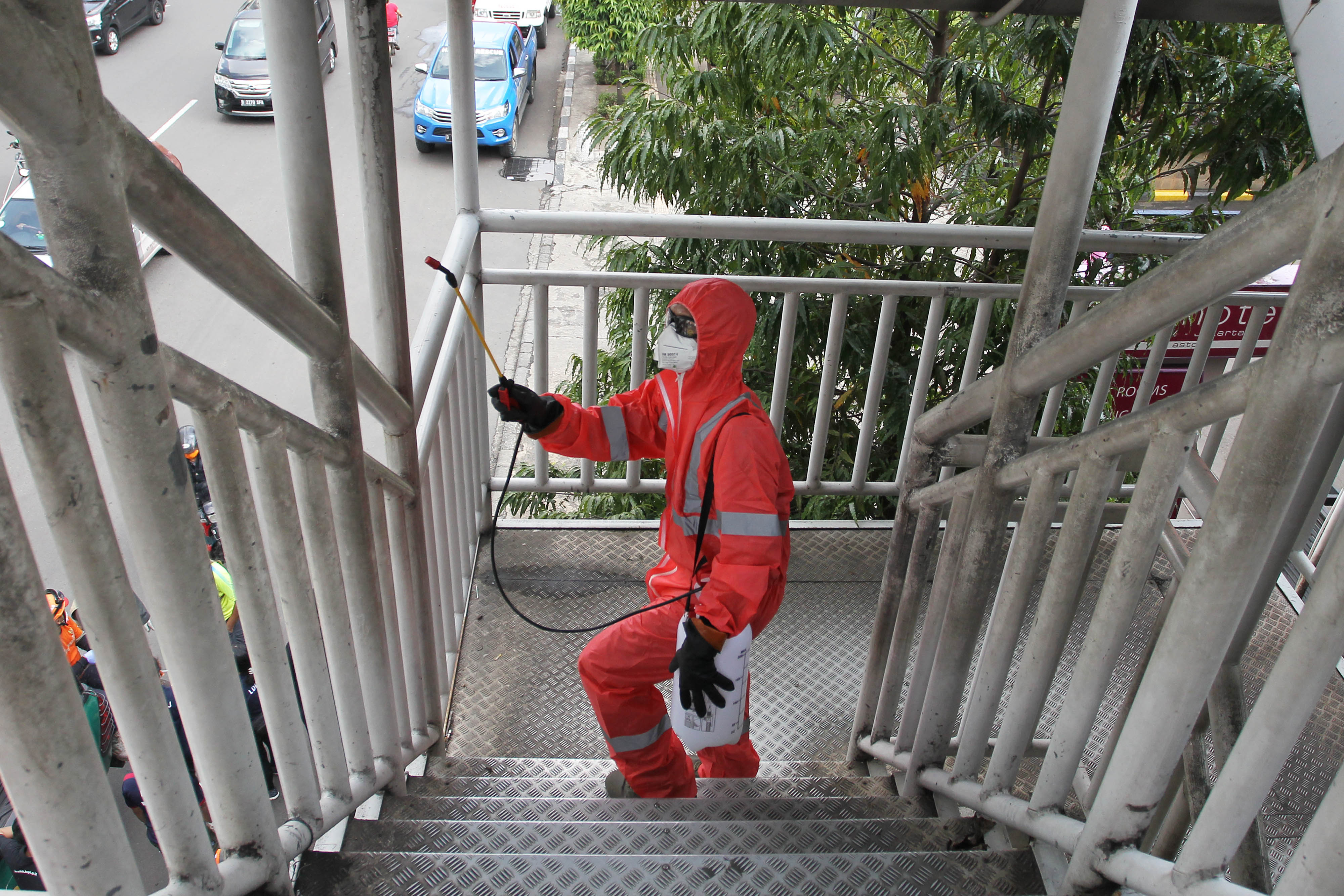  Petugas menyemprotkan cairan disinfektan di sejumlah jembatan penyeberangan Orang di sepanjang Jalan Gajah Mada, Jakarta.
