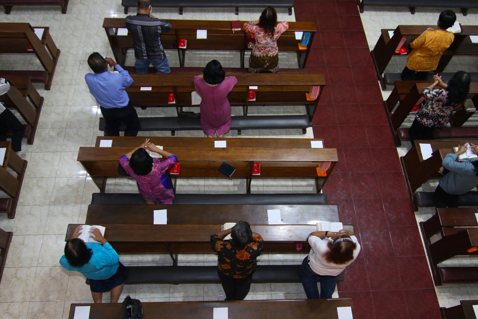  Umat Katolik melaksanakan ibadah misa harian dengan menjaga jarak di Gereja Maria Ratu Damai, Banyuwangi, Jawa Timur, Jumat (20/3/2020). 