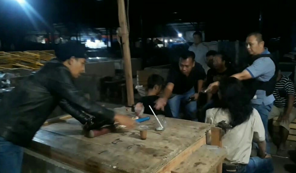 Wakapolres Tasikmalaya Kota, Kompol Ricky Aries Setiawan (kaos biru) memimpin penggrebegan judi kemiri di pasar Cikurubuk, Tasikmalaya.