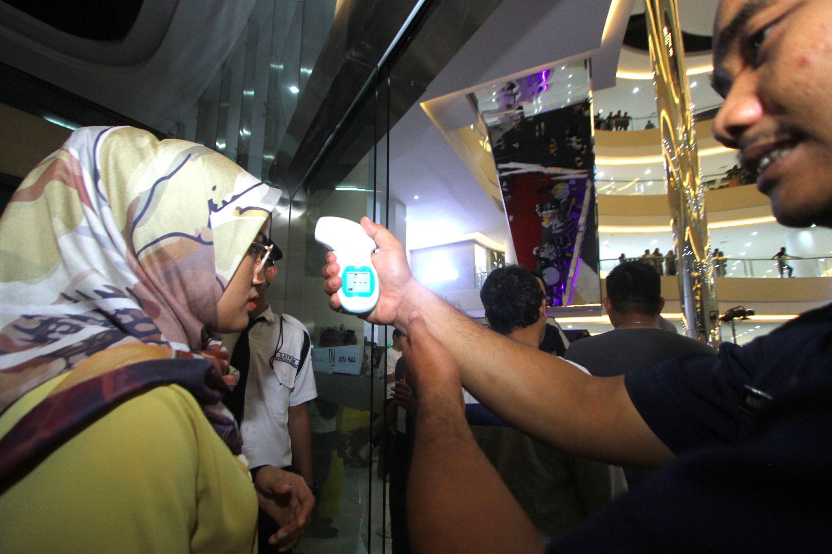 Ilustrasi--Petugas mengukur suhu tubuh pengunjung saat Pekan QRIS Nasional 2020 di Duta Mall Banjarmasin, Kalimantan Selatan.