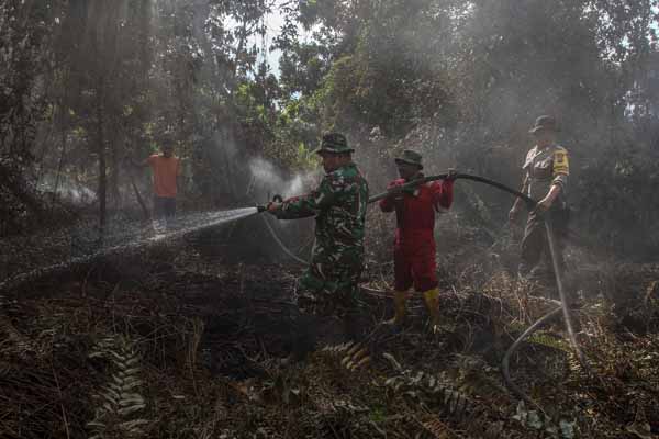  Petugas gabungan dari Polri, TNI, BPBD dan Masyarakat Peduli Api (MPA) Kota Pekanbaru berusaha memadamkan bara api.