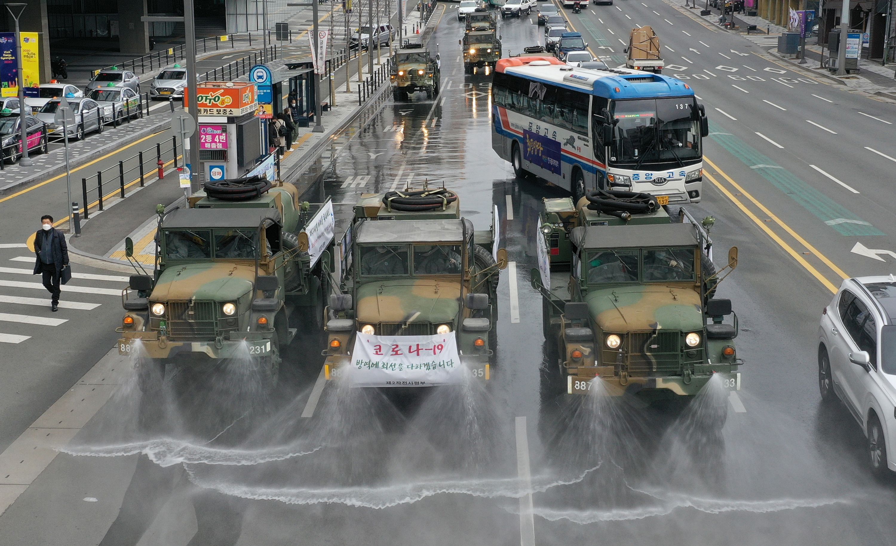 Kendaraan militer menyemprotkan cairan disinfektan ke jalan di dekat stasion Dangdaegu, Daegu, Korsel, untuk mencegah COVID-1.