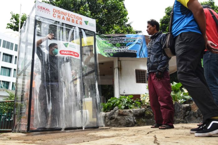 Warga saat mencoba fasilitas Disinfection Chamber di Kawasan Blok M, Jakarta pada Selasa (24/3/2020).