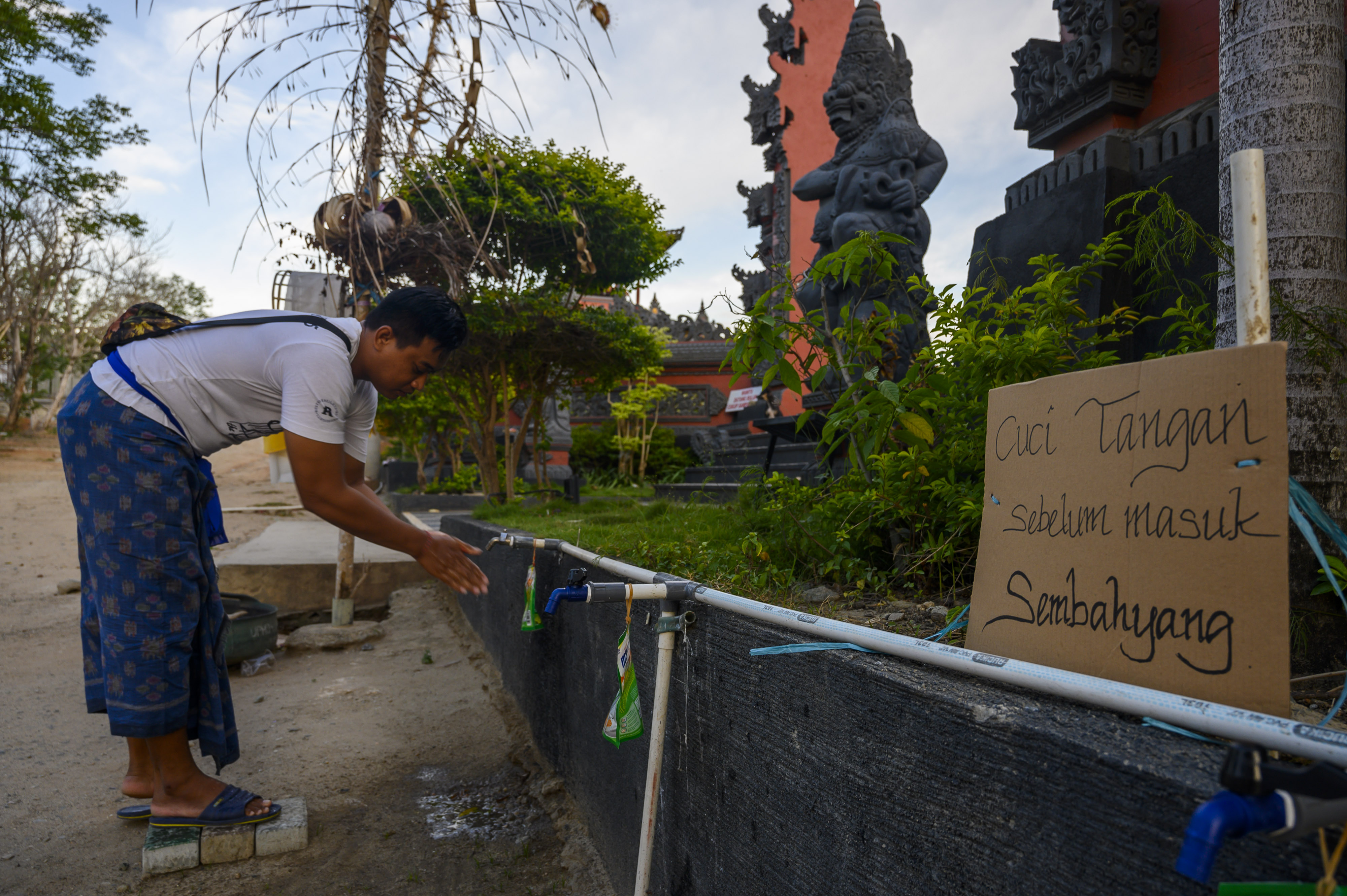  Seorang umat Hindu mencuci tangan sebelum melakukan sembahyag di Pura Agung Jagatnatha Wana Kertha, Palu, Sulteng, Selasa (24/3/2020).