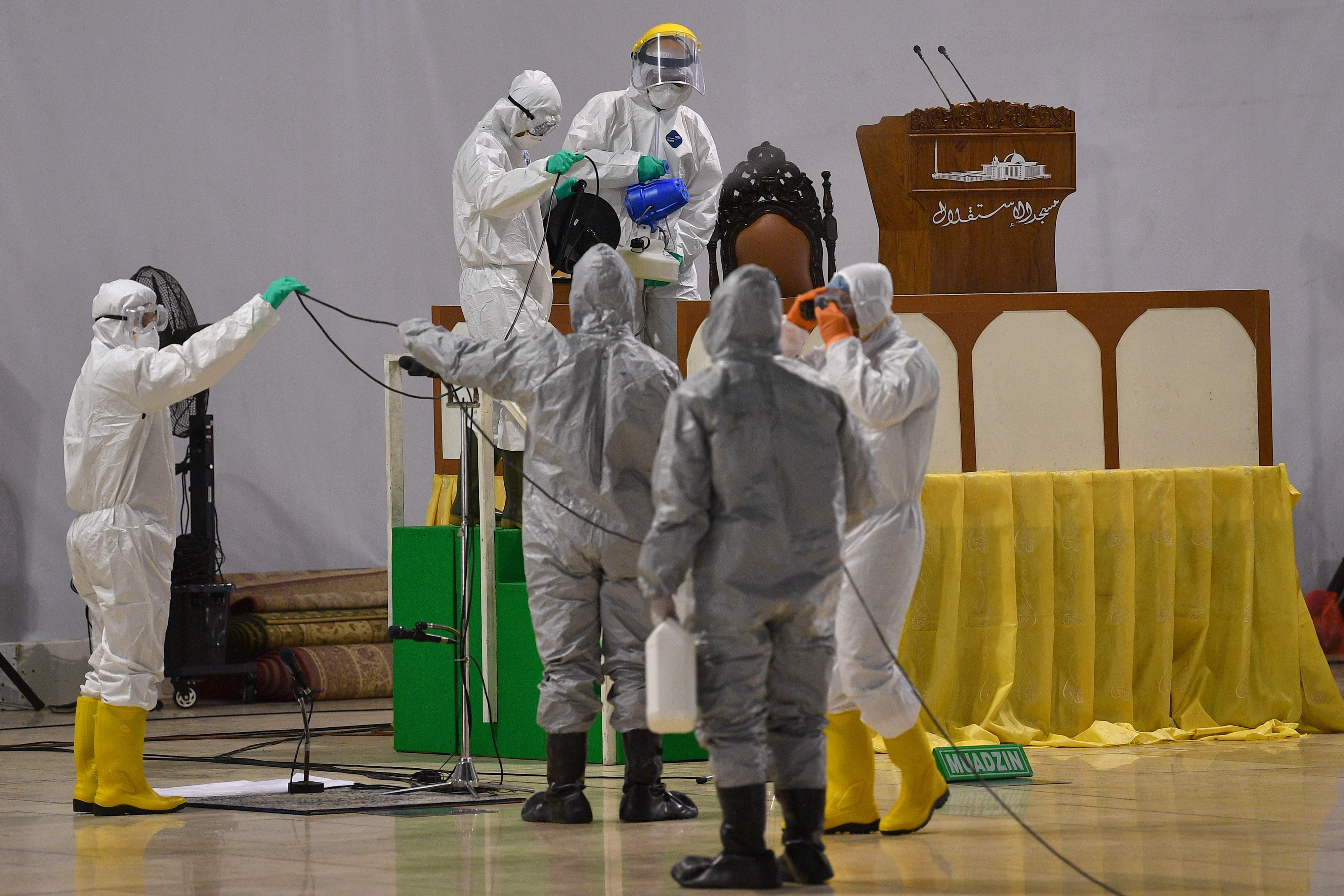 Petugas gabungan menyemprotkan cairan desinfektan di Masjid Istiqlal, Jakarta Pusat, Jumat (13/3/2020). 