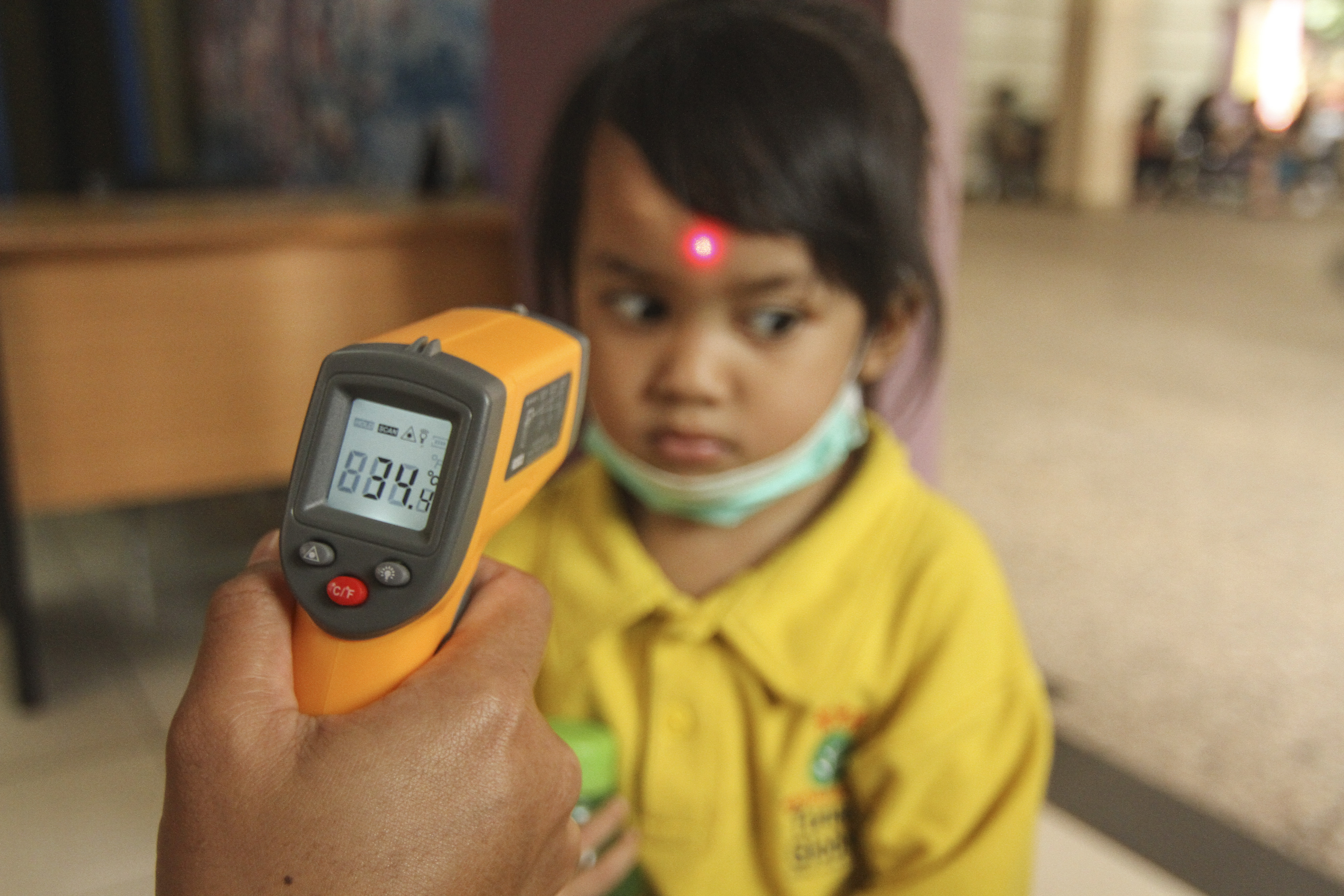 Petugas sekolah memeriksa suhu tubuh siswa menggunakan termometer non kontak saat sosialisasi di Sekolah Tunas Global, Depok, Jawa Barat