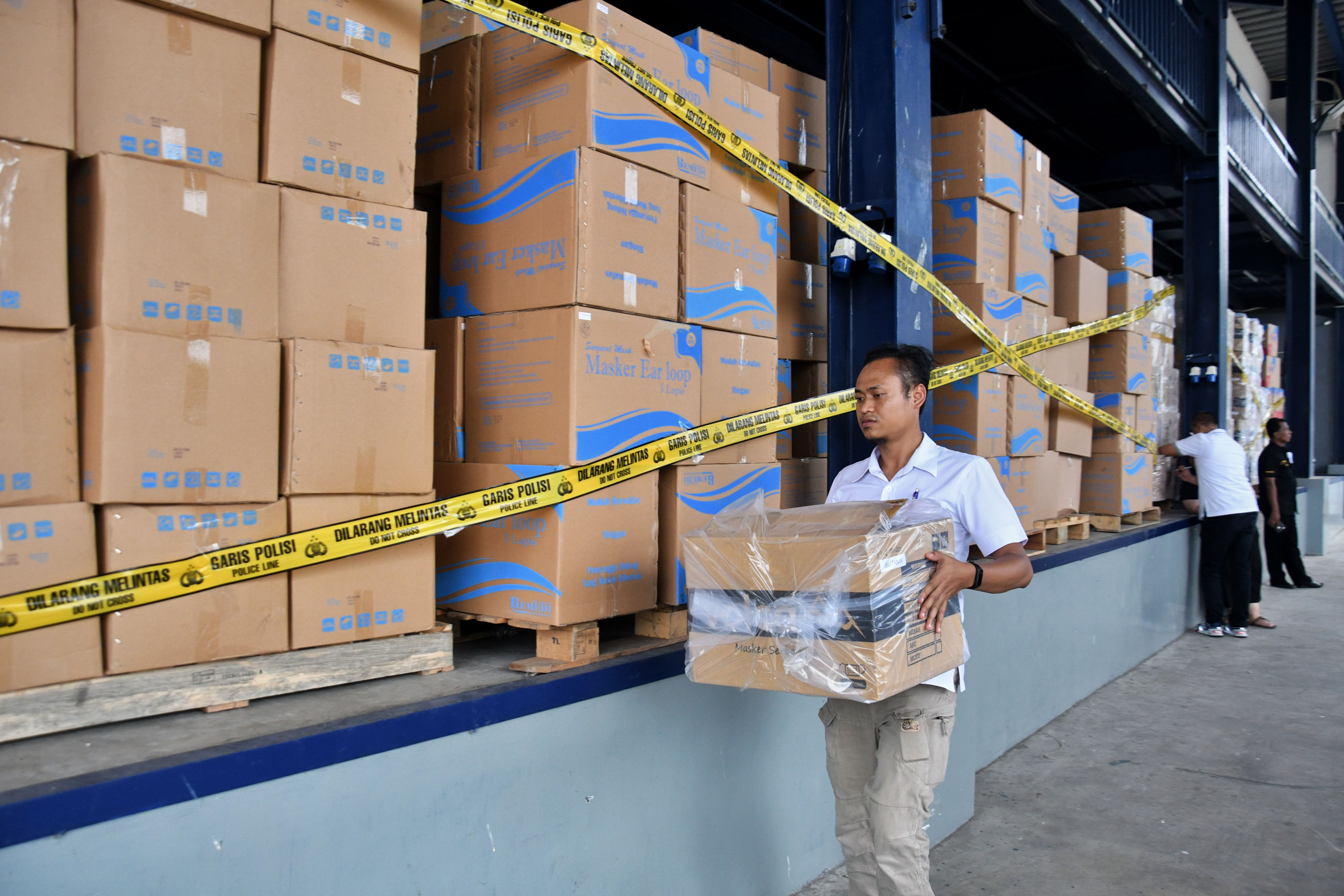 Petugas menata barang bukti penimbunan masker di salah satu gudang di Tangerang, Banten, Rabu (4/3). 
