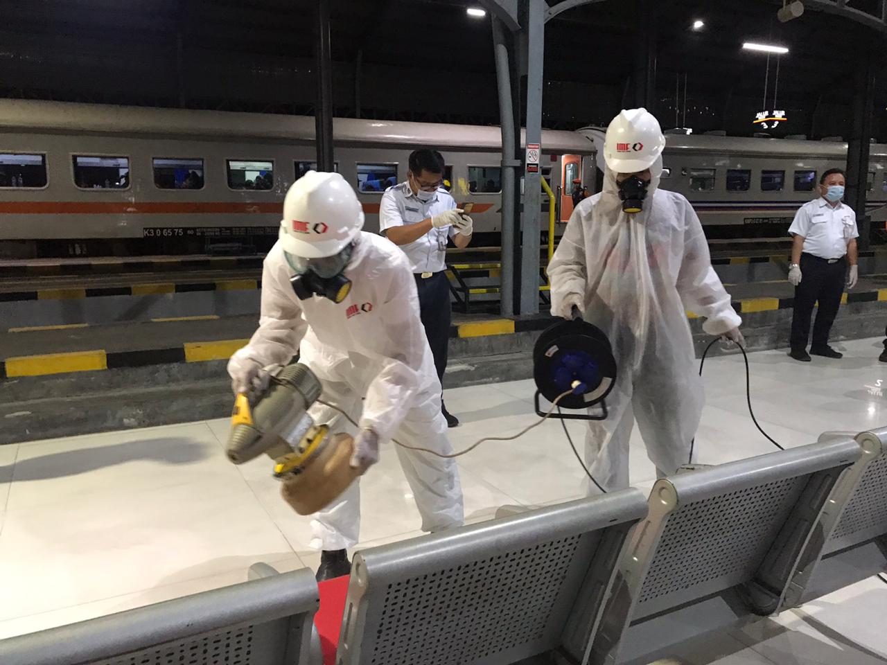 Petugas sednag menyemprotkan disinfektan di kursi di stasiun Purwosari