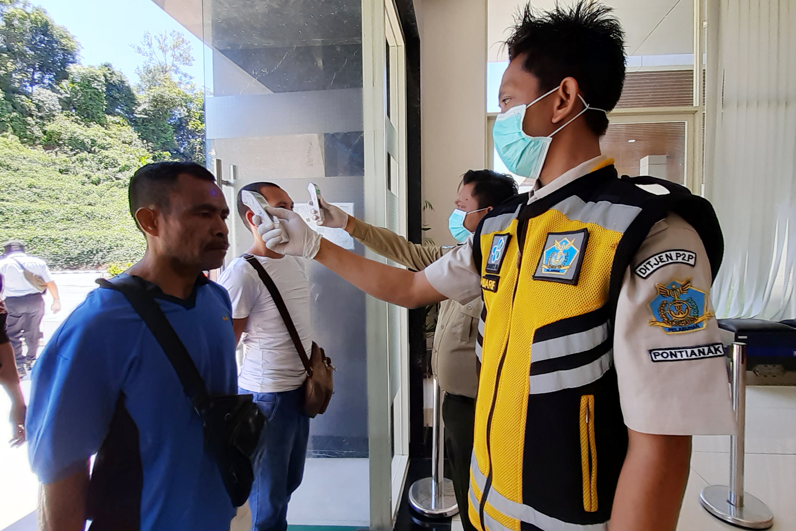 Ilustrasi--Seorang pekerja migran Indonesia menjalani pemeriksaan suhu tubuh saat tiba di PLBN Entikong, Kabupaten Sanggau.