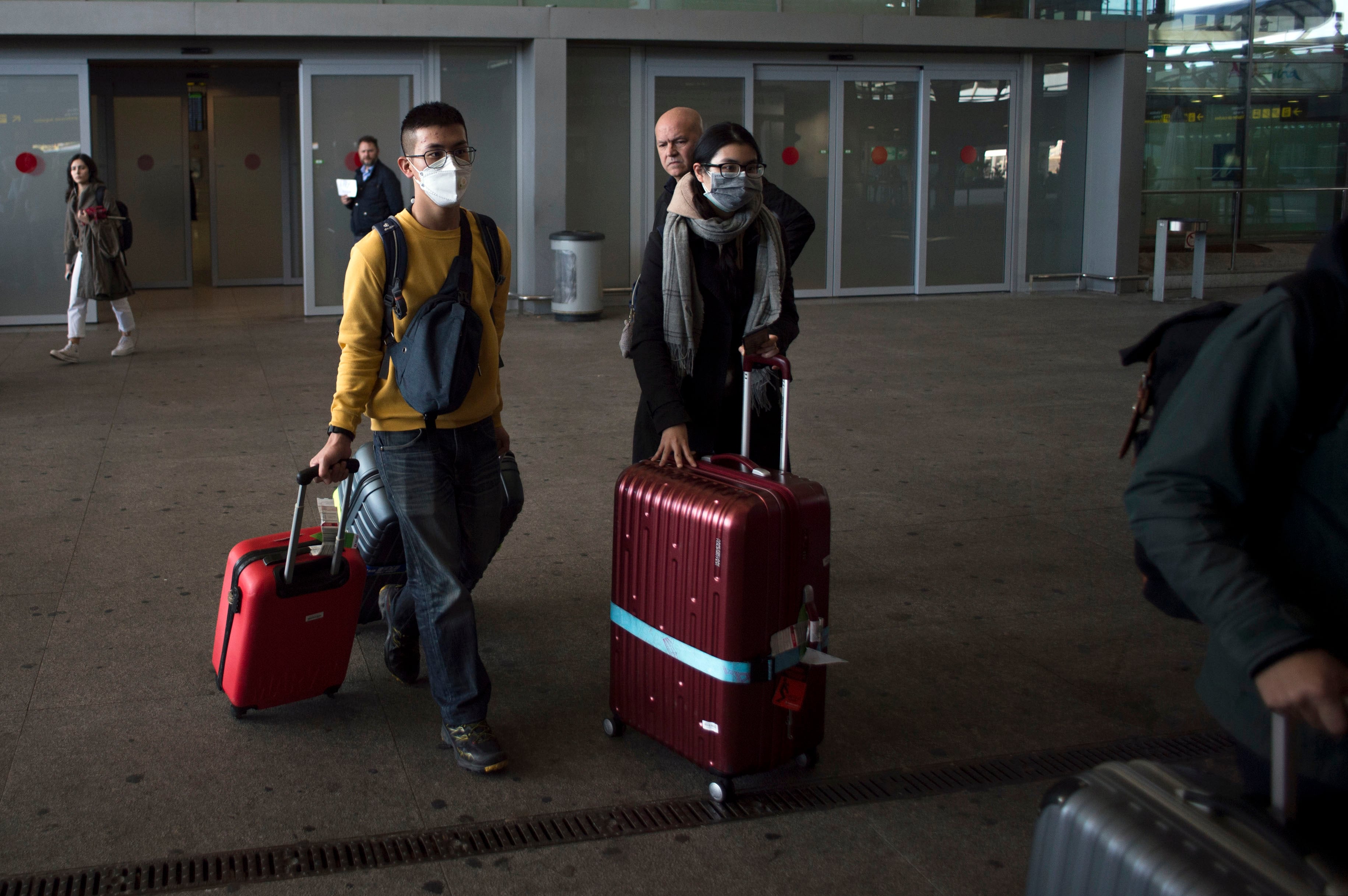 Dua penumpang mengenakan masker saat tiba di Bandara Costa del Sol, Malaga, Spanyol.