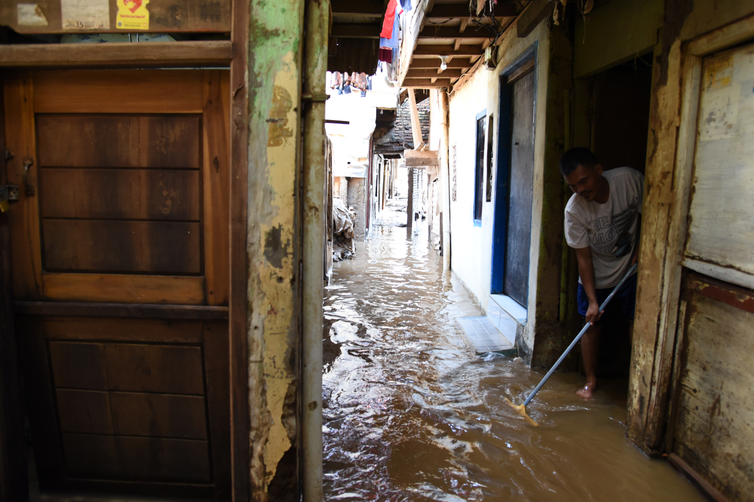 Warga membersihkan rumah mereka dari lumpur usai banjir di kawasan Kebon Pala, Jatinegara, Jakarta Timur.
