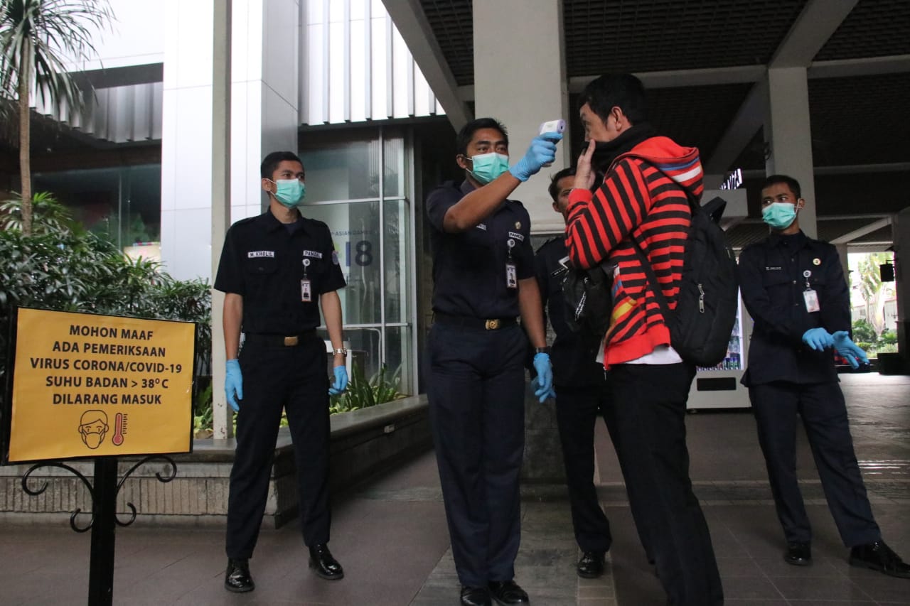 Petugas memeriksa suhu tubuh pengunjung yang akan masuk ke dalam Balai Kota DKI Jakarta.
