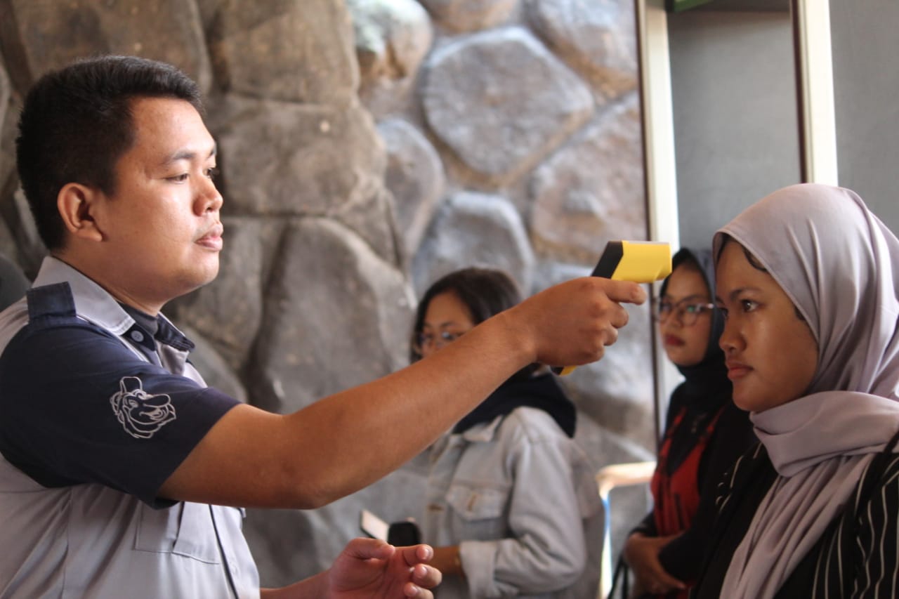 Petugas memeriksa suhu tubuh pengunjung di Dermaga Ancol.