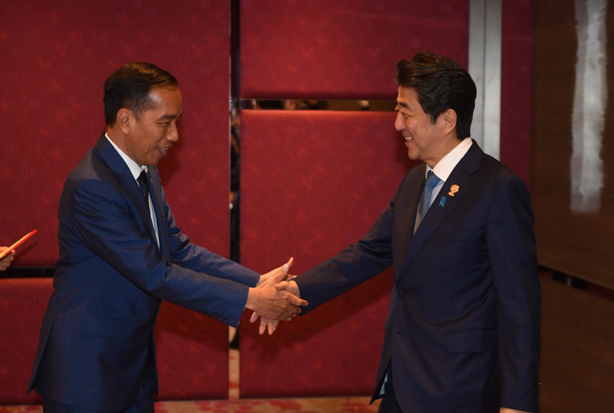 Presiden Joko Widodo berjabat tangan dengan PM Jepang Shinzo Abe dalam pertemuan bilateral di sela KTT ASEAN.