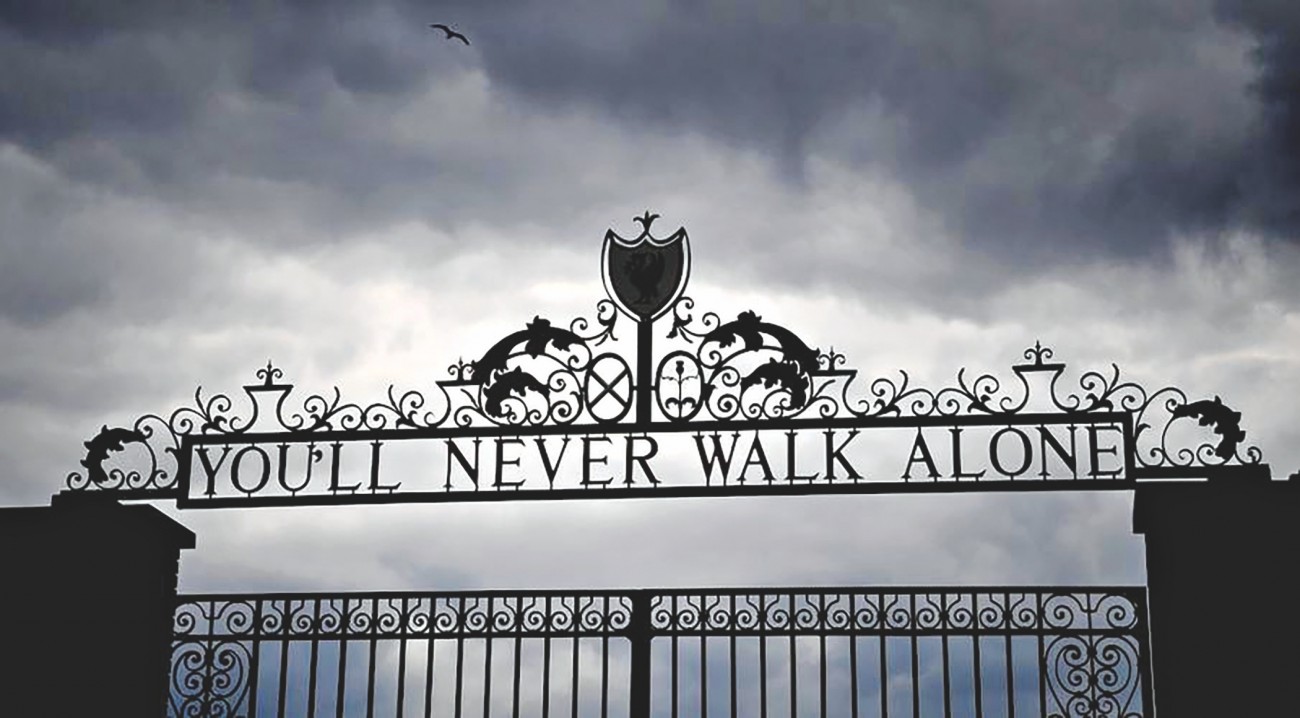 Logo You'll Never Walk Alone terlihat di gerbang stadion Anfield, markas Liverpool