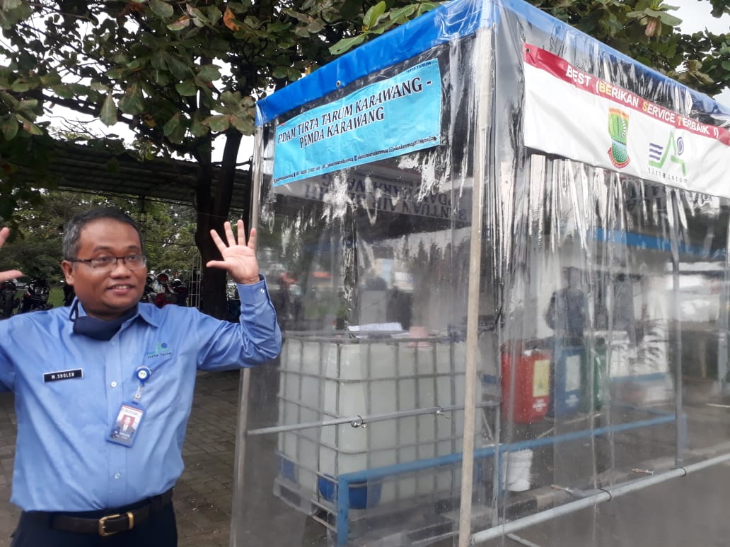 Direktur PDAM Tirta Tarum, Muhammad Sholeh  bersama bilik disinfektan karya PDAM setempat
