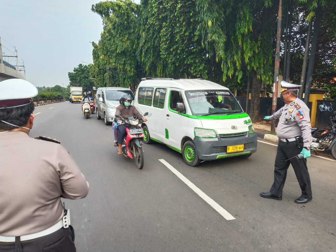 Aparat melaksanakan pengawasan dalam penerapan pembatasan sosial berskala besar (PSBB) di Jalan Lebak Bulus, Jakarta Selatan (10/4/2020).