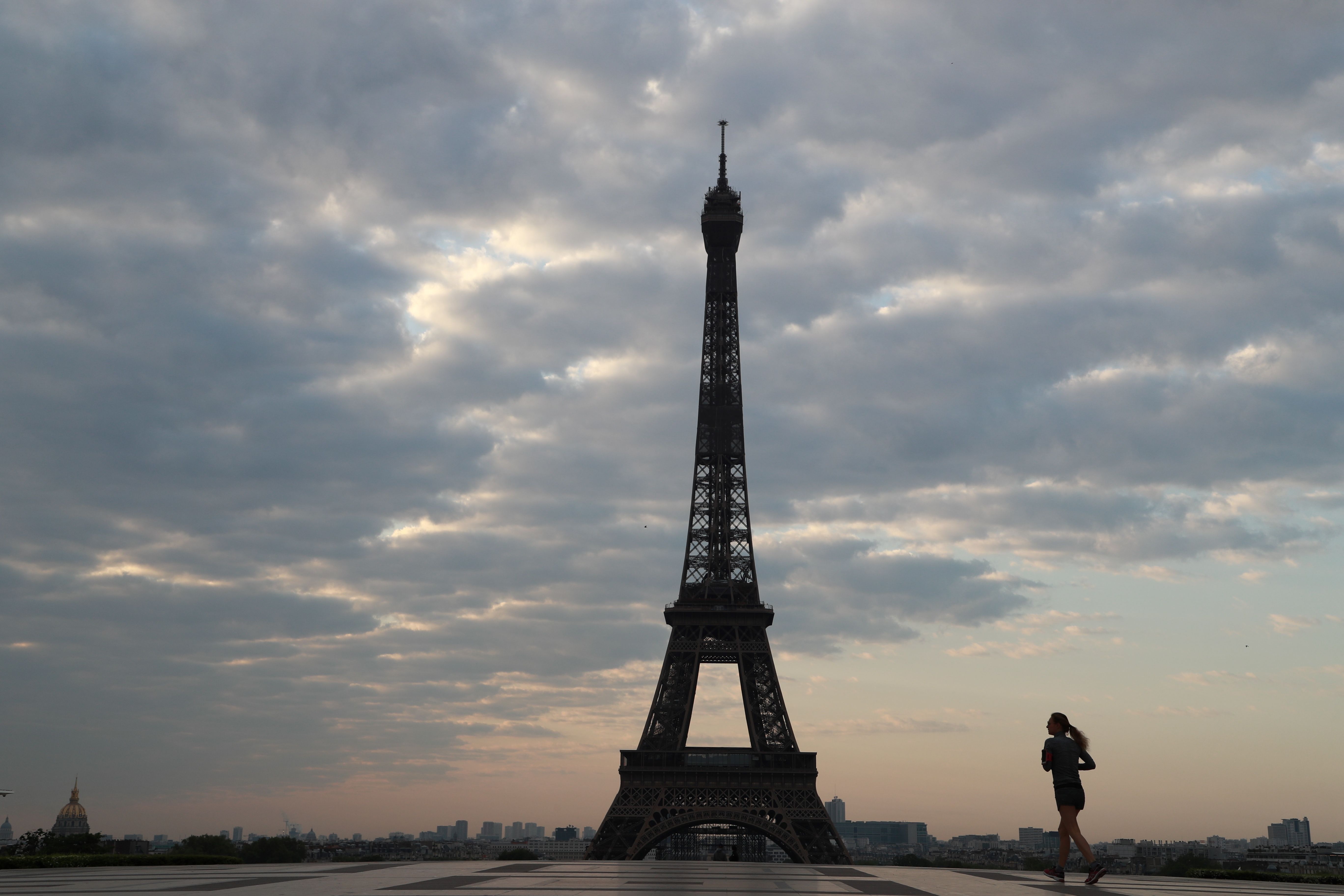 Seorang wanita berolahraga di Esplanade du Trocadero, di Paris, Jumat (24/4), saat negara itu dikunci untuk mencegah penyebaran covid-19.