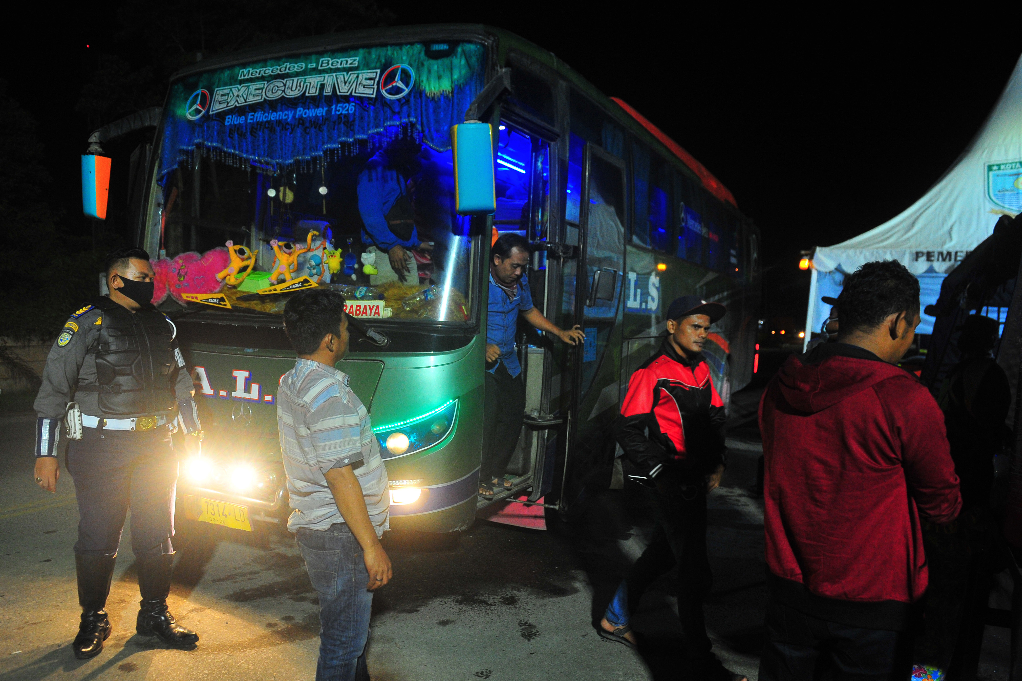 Petugas mengarahkan penumpang bus antar kota antar provinsi (AKAP) untuk pemeriksaan suhu tubuh saat memasuki Kota Jambi, Senin (13/4).