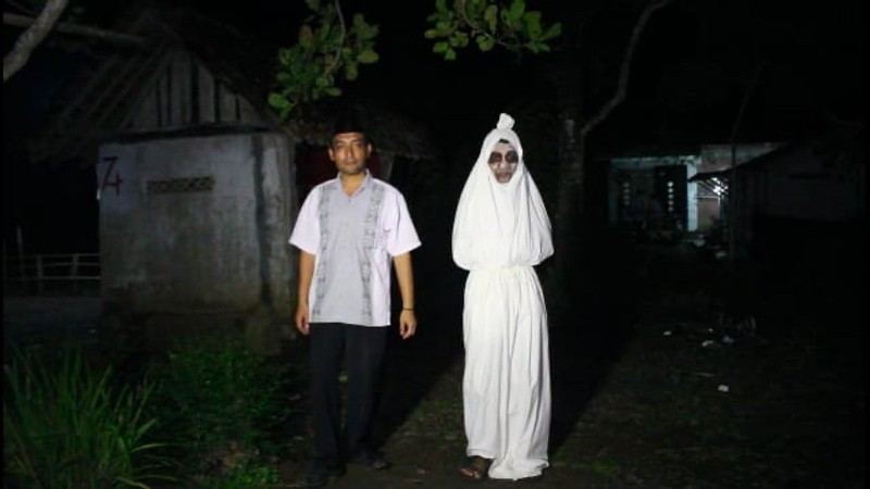 Kepala Desa Pogungjurutengah, Slamet Widodo ditemani pocong untuk mengimbau warga tidak mudik.