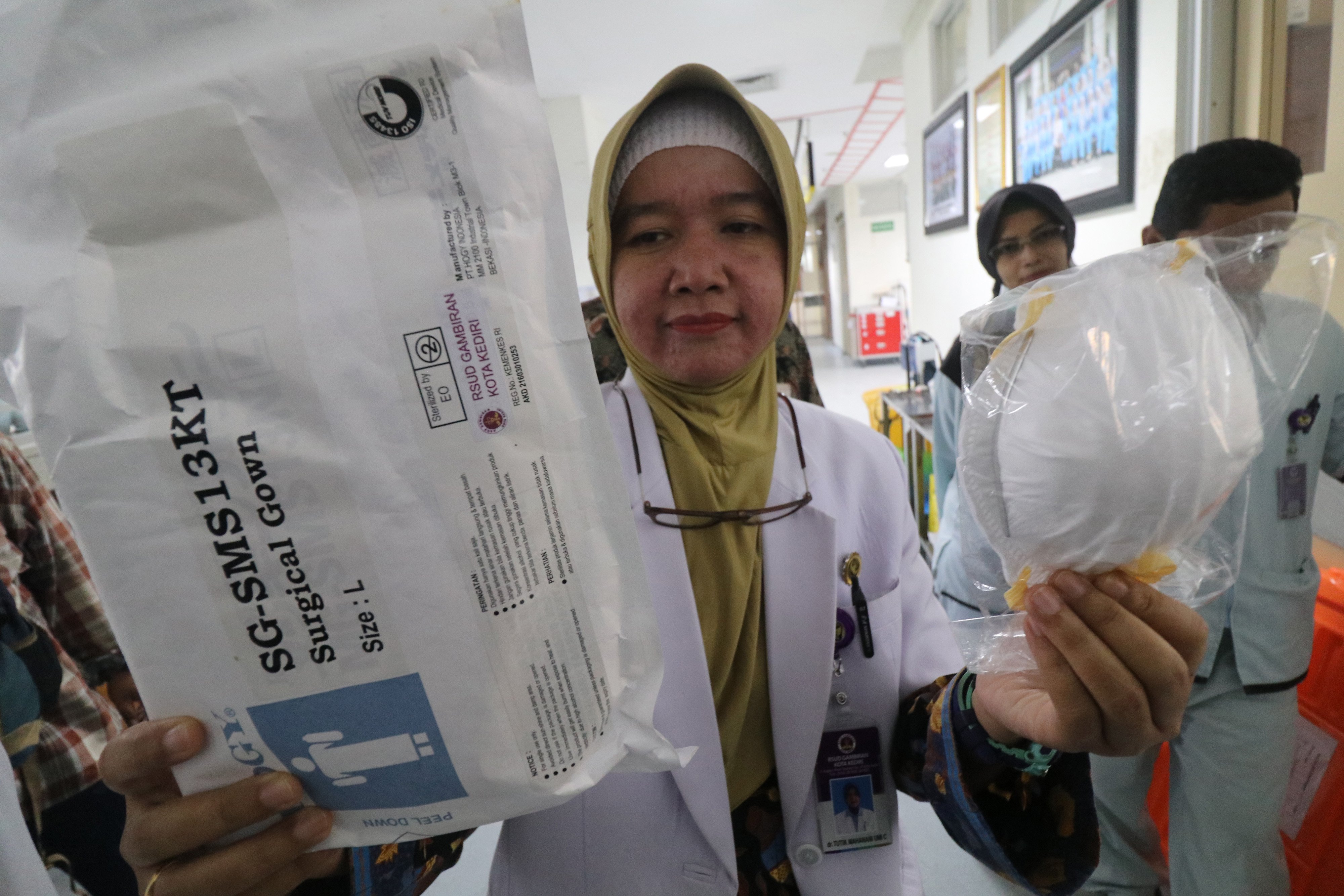 Seorang dokter menunjukkan masker dan baju pelindung diri untuk menghadapi wabah covid-19.