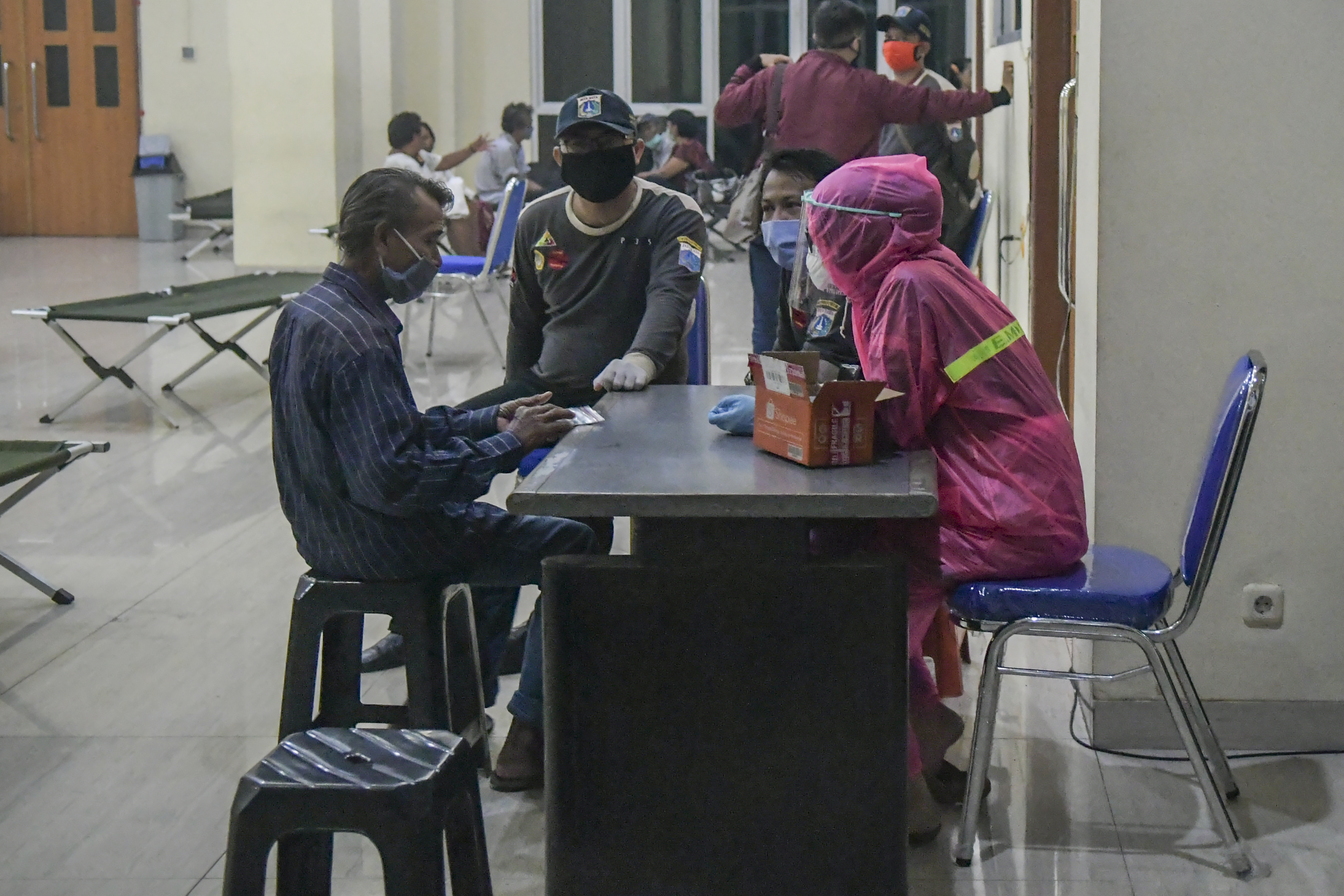 Petugas medis memeriksa tuna wisma di GOR Tanah Abang, Jakarta.