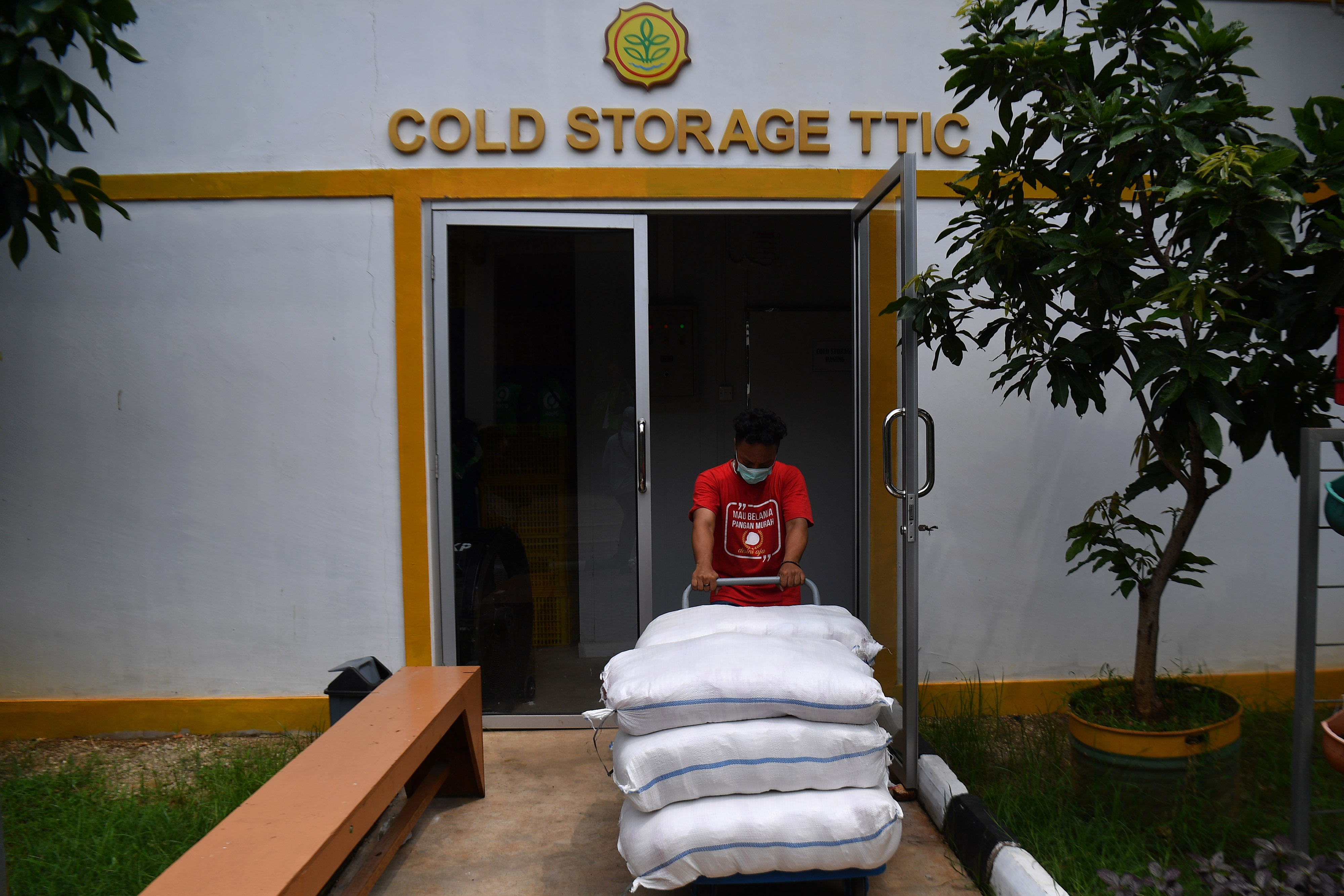 Pekerja membawa karung berisi beras di Toko Tani Indonesia Centre, Pasar Minggu, Jakarta Selatan, Selasa (21/4/2020). 