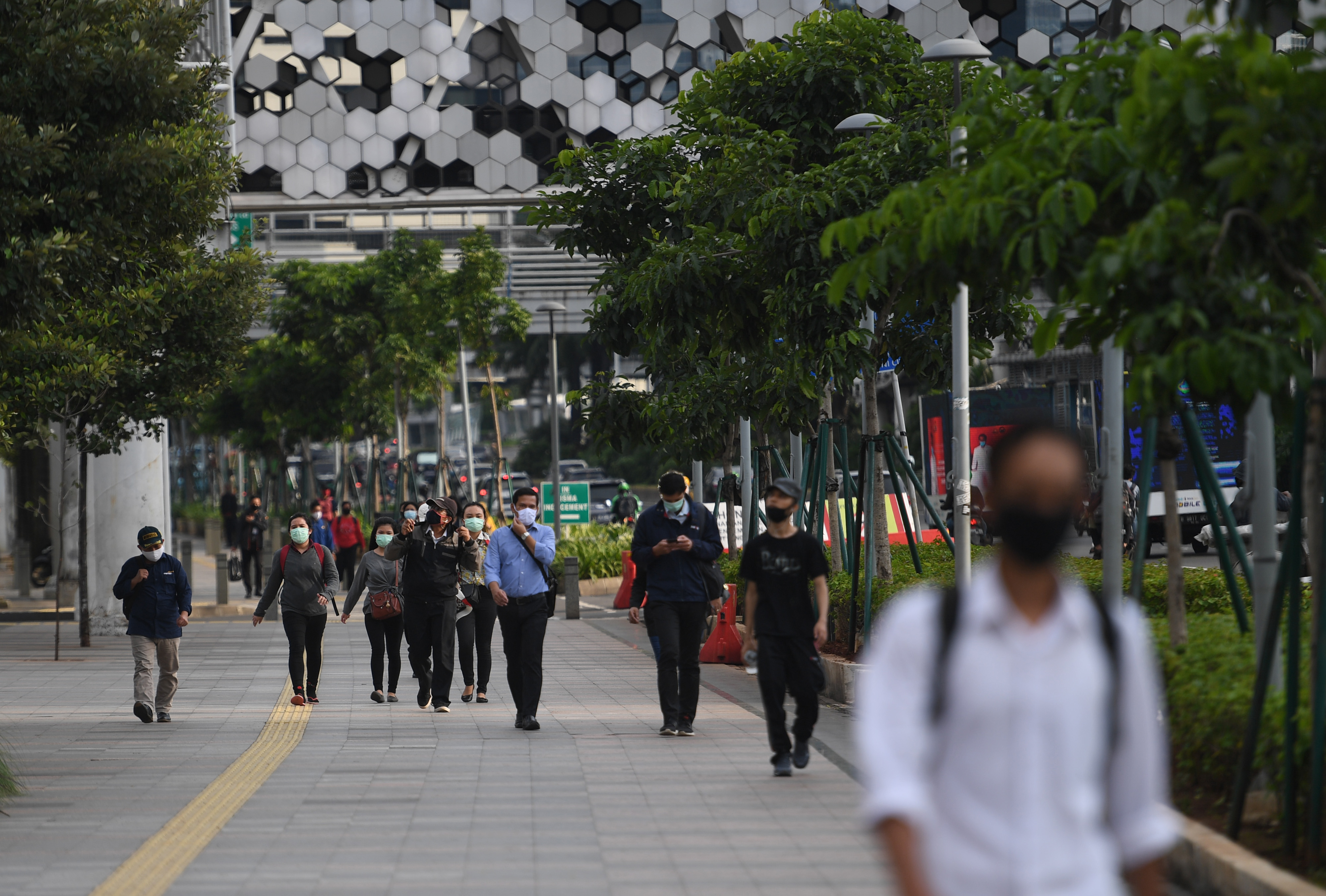 Sejumlah pekerja berjalan di Jalan Jenderal Sudirman, Jakarta, Kamis (16/4/2020). 