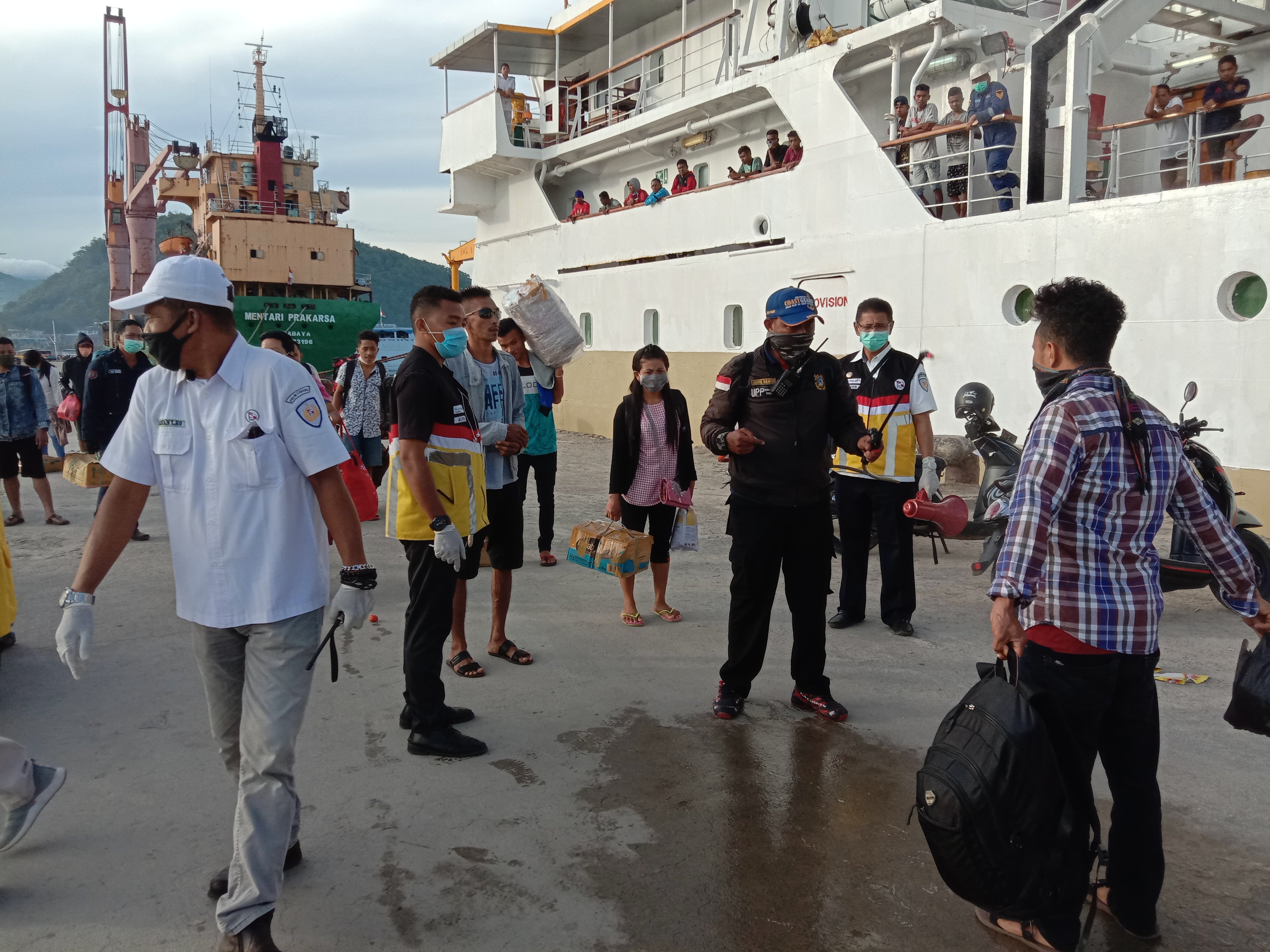 Petugas menyemprotkan cairan disinfektan kepada penumpang yang baru turun dari Kapal Pelni di Pelabuhan Labuan Bajo, NTT. 