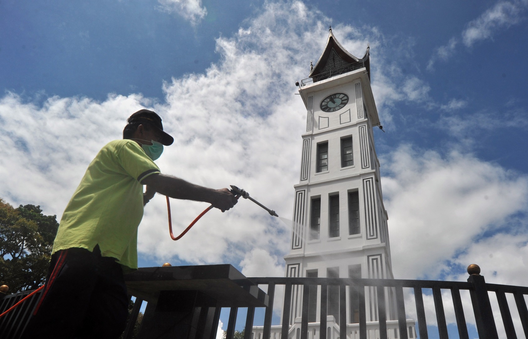 Petugas menyemprotkan disinfektan di kawasan Jam Gadang, Bukittinggi, Sumatera Barat, Minggu (22/3/2020). 