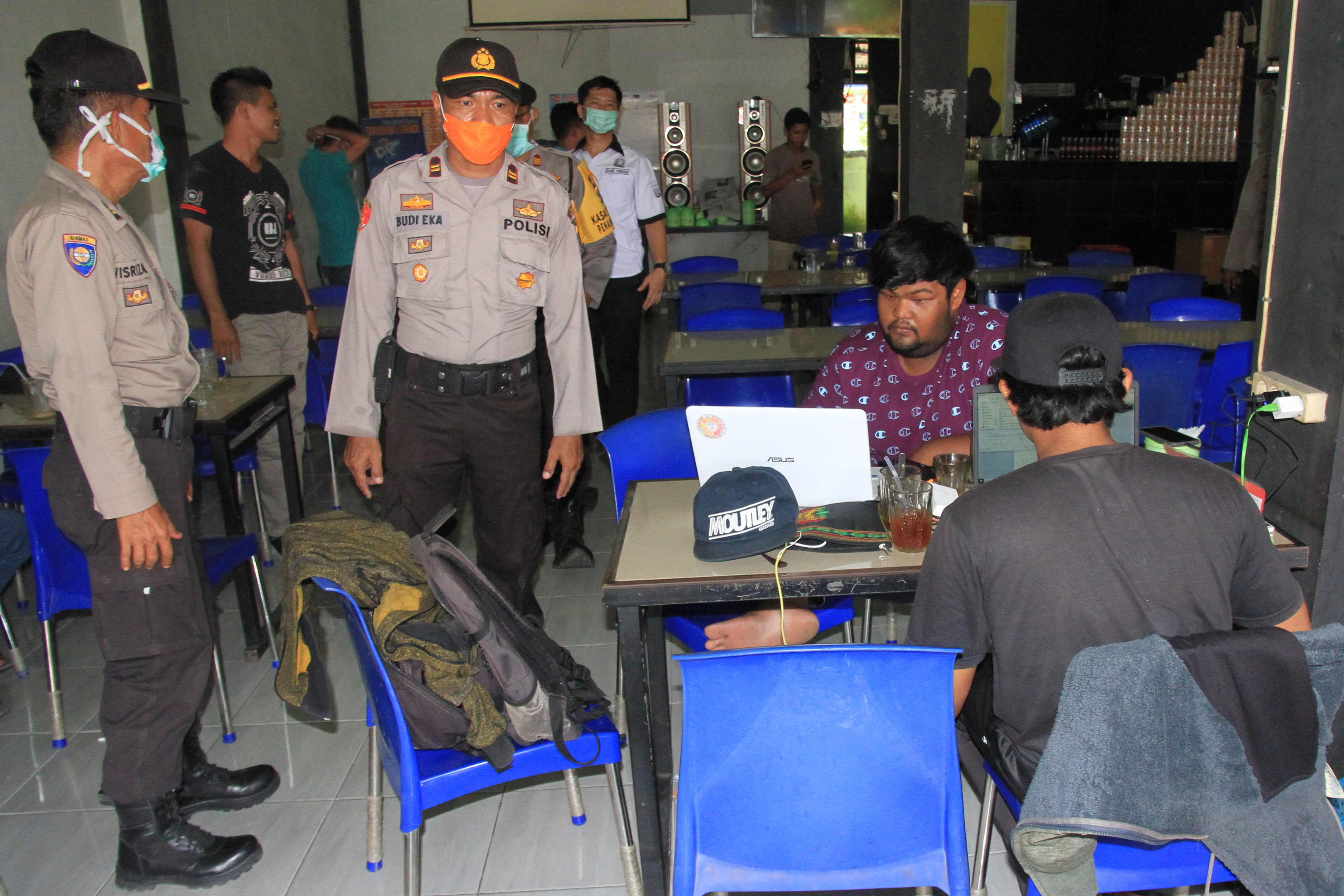 Ilustrasi-- Personel Kepolisian Polres Aceh Barat mengimbau warga menghindari tempat keramaian di salah satu warung kopi di Meulaboh.