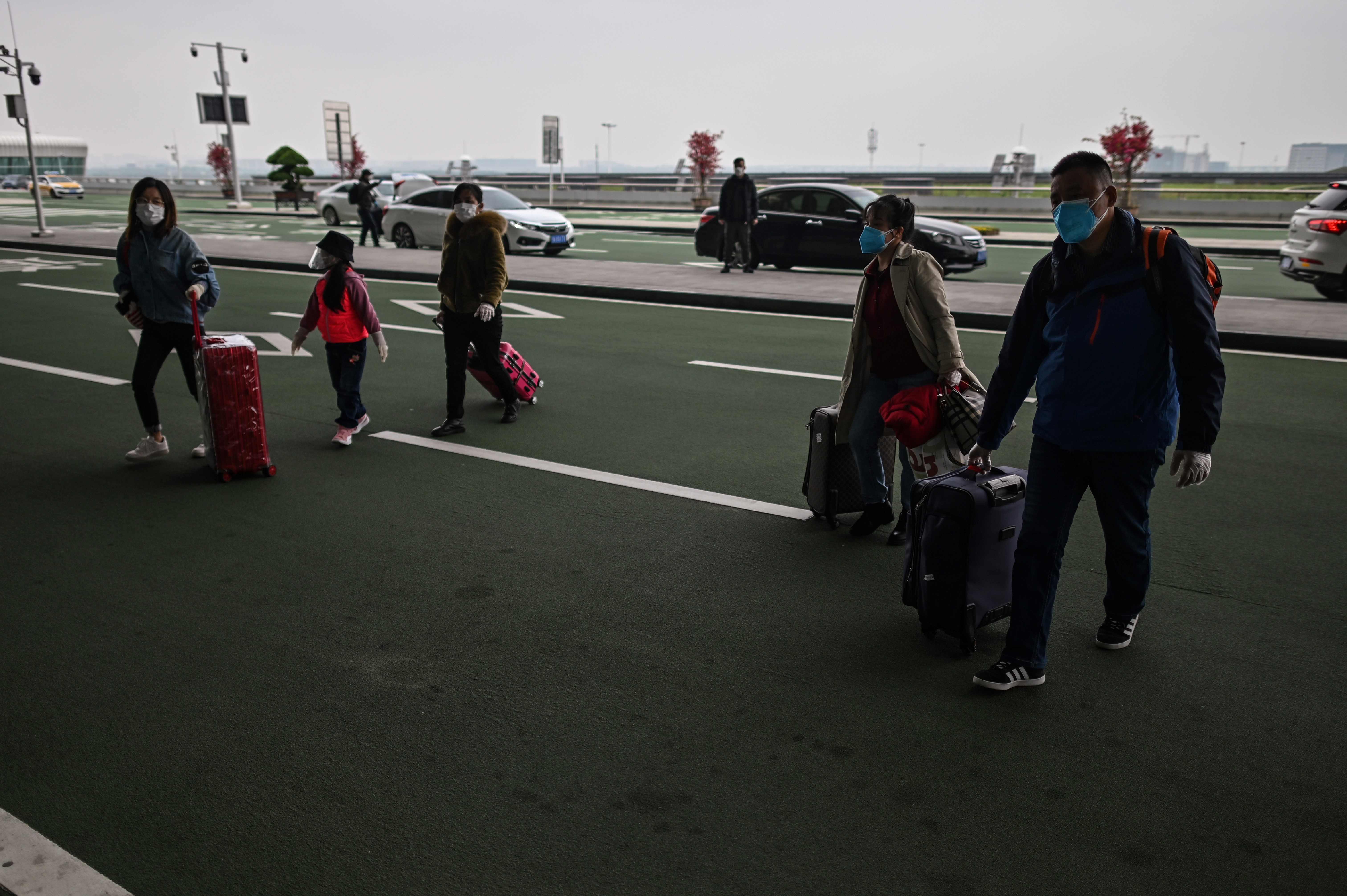  Para penumpang memakai masker sebelum masuk ke Tianhe Airport di Wuhan (11/4)