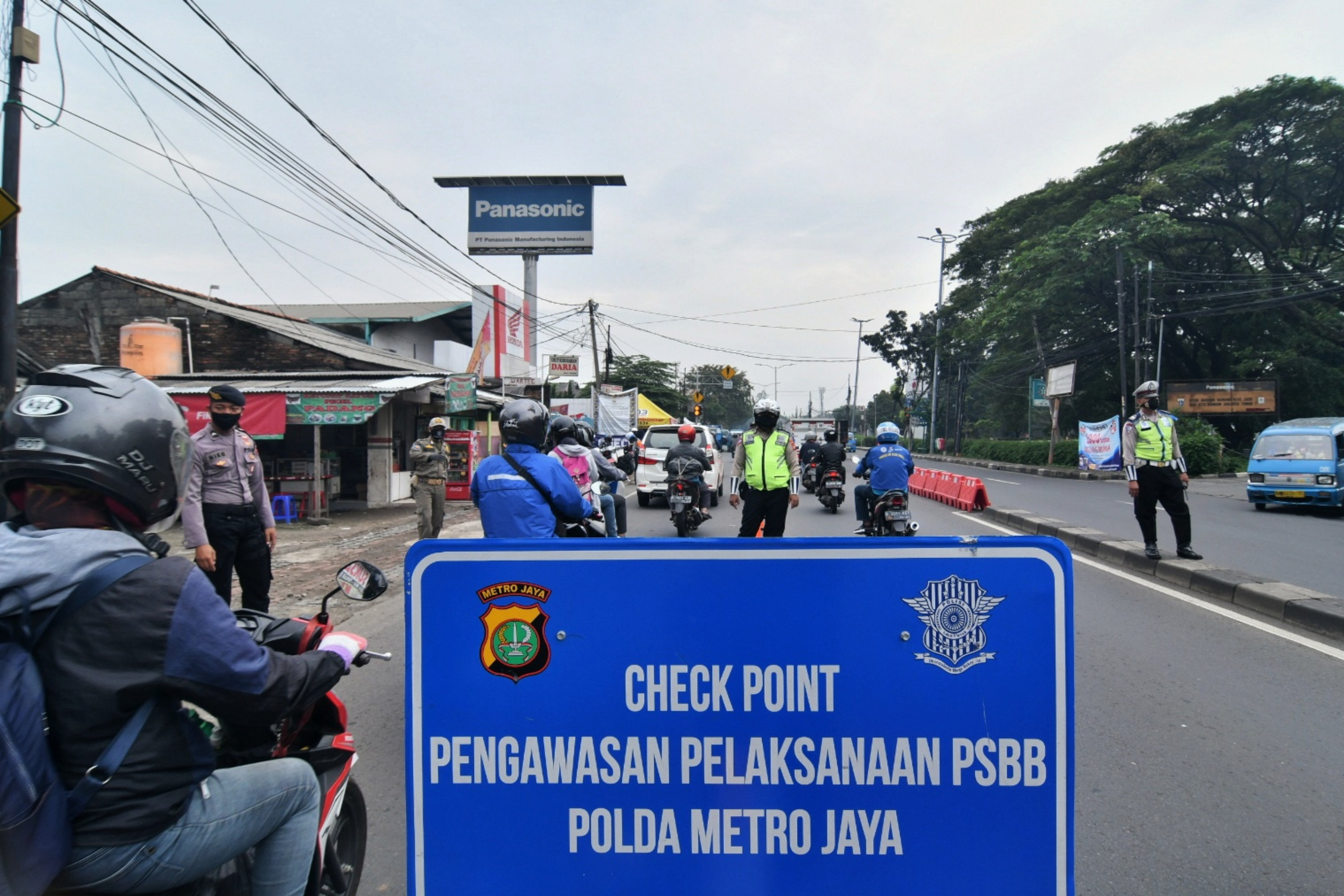 Petugas gabungan melakukan pengawasan di Check point PSBB Jl Raya Bogor, perbatasan Jakarta Timur-Depok, Selasa (28/4). 