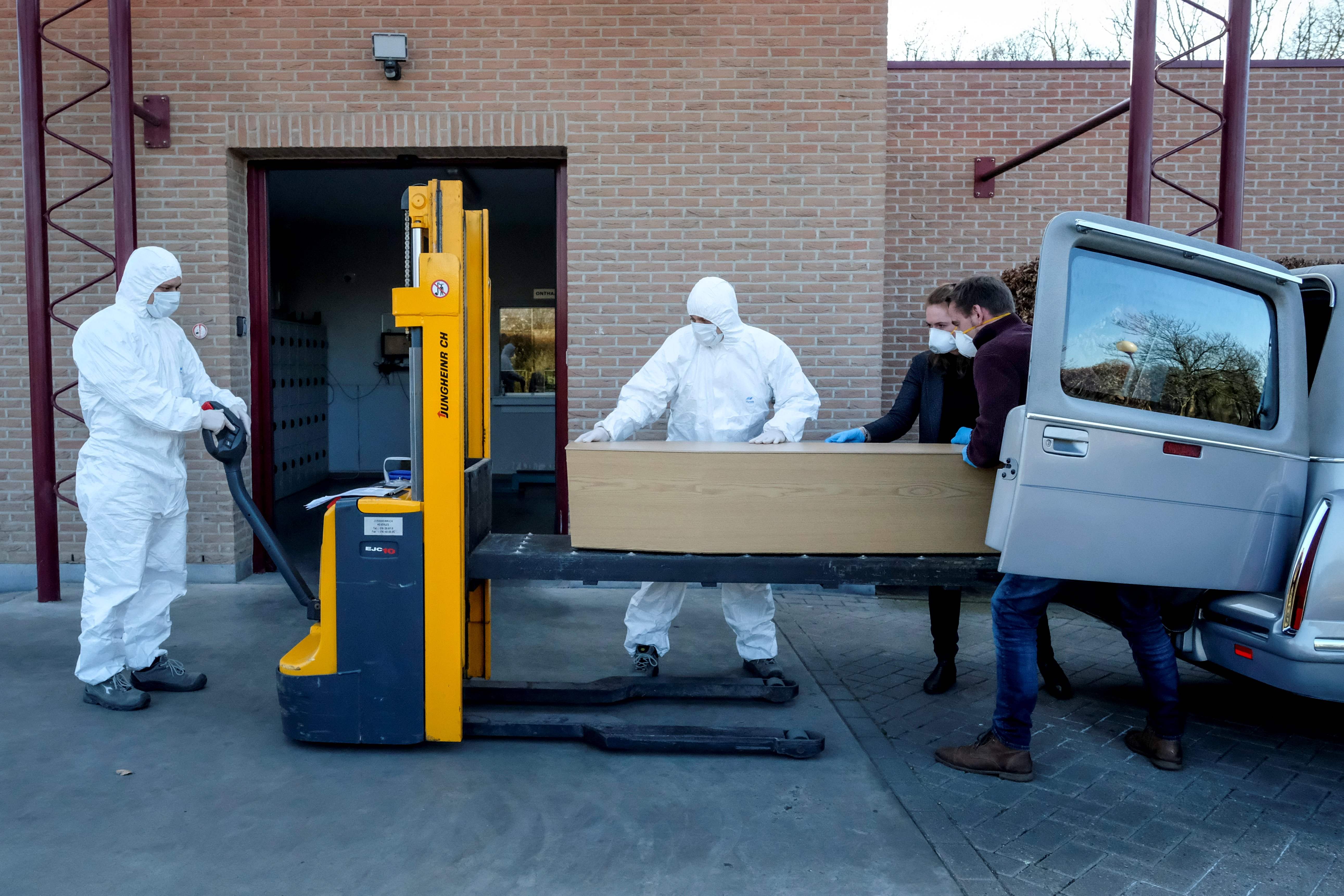 Pekerja di krematorium Wilrijk di Antwerp memakai personal protective equipment atau APD (30/3) lalu