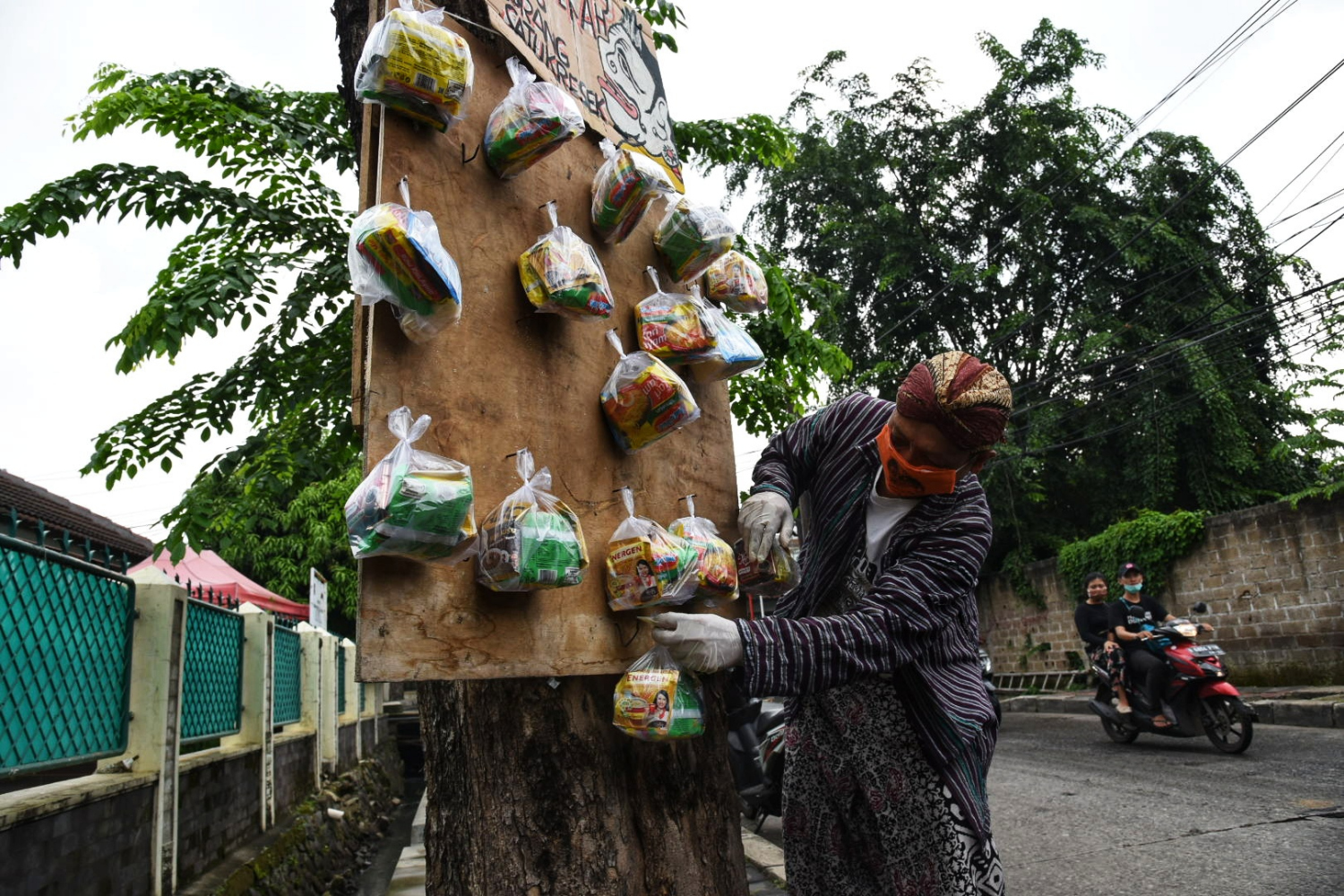  Seniman wayang uwuh, Iskandar Hardjodimuljo menggantungkan sumbangan paket bahan makanan di pohon di jalan Cawang Baru Utara Jkt