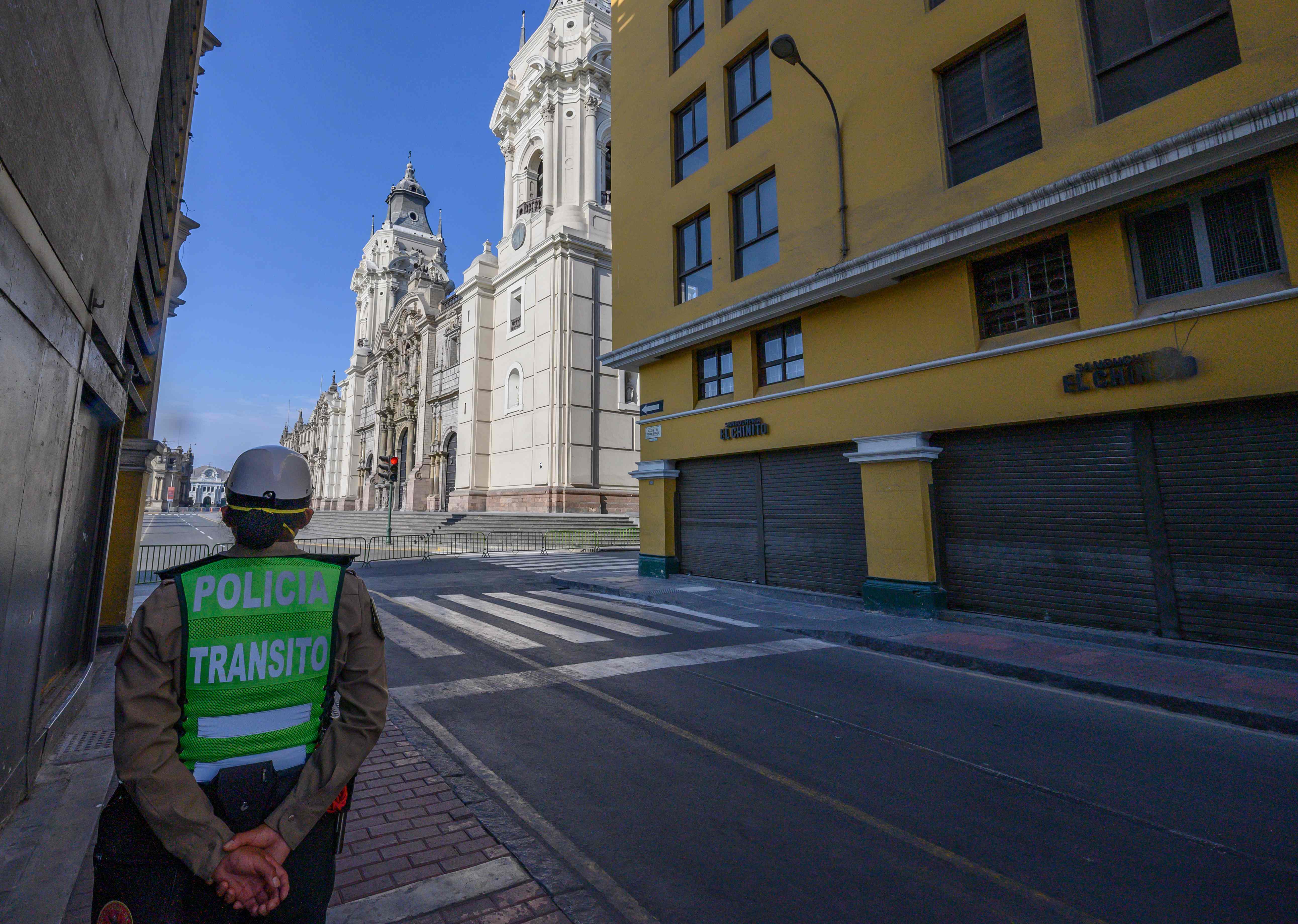 Seorang polisi wanita berpatroli di jalan yang berdekatan dengan alun-alun utama Lima, Plaza de Armas.