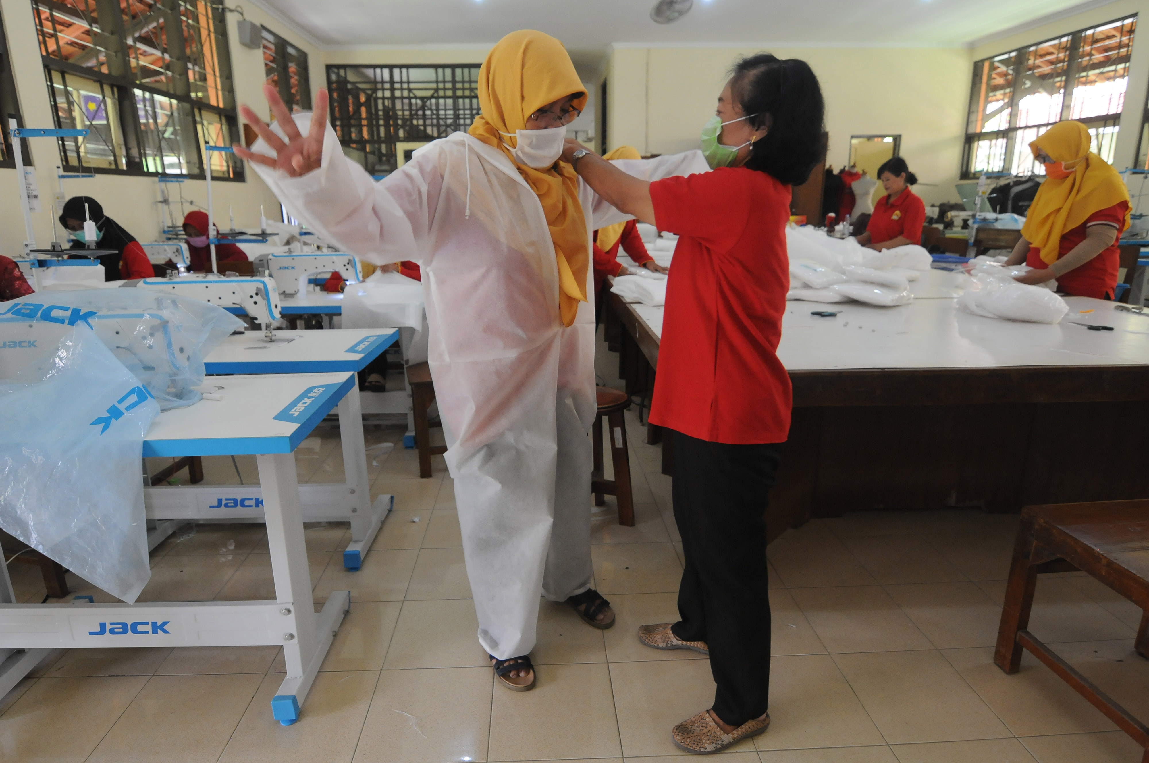 Seorang guru mencoba baju alat pelindung diri (APD) yang telah jadi di SMK Negeri 3 Klaten, Jawa Tengah, Kamis (2/4/2020)