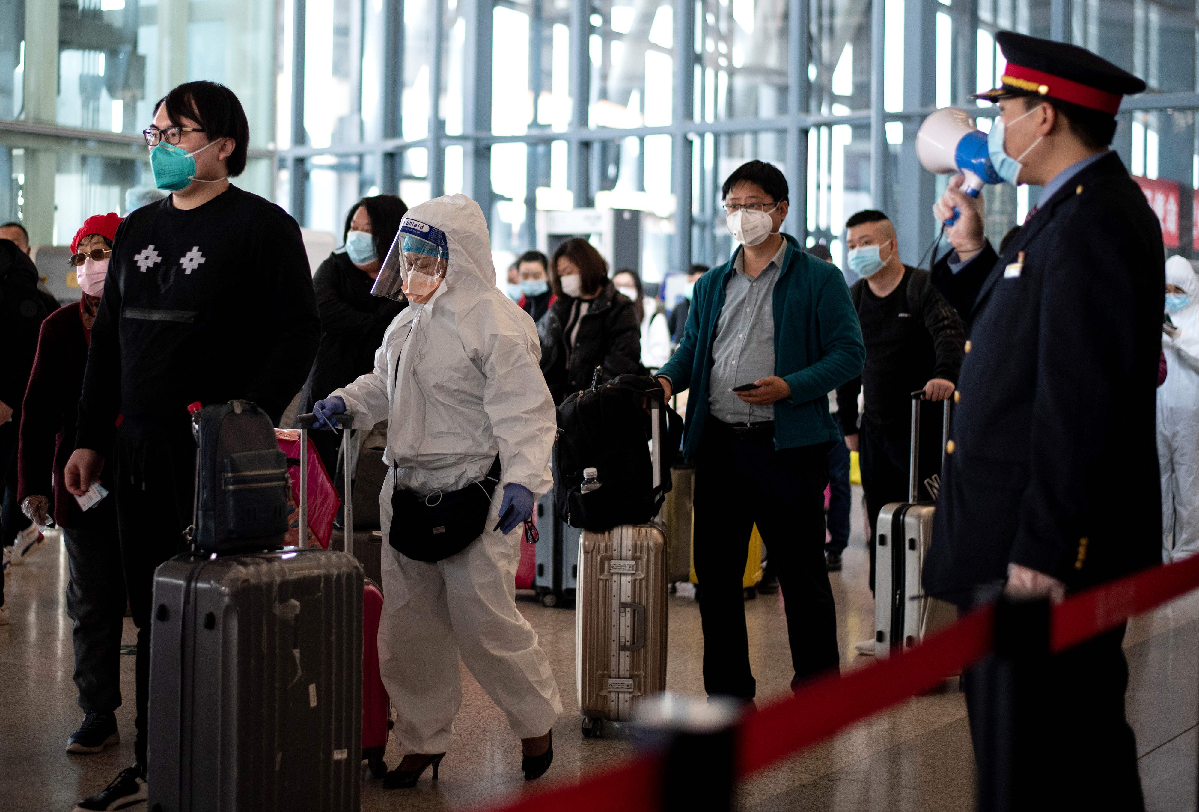Warga mengantre di stasiun kereta di Wuhan untuk menaiki kereta ke Beijing.